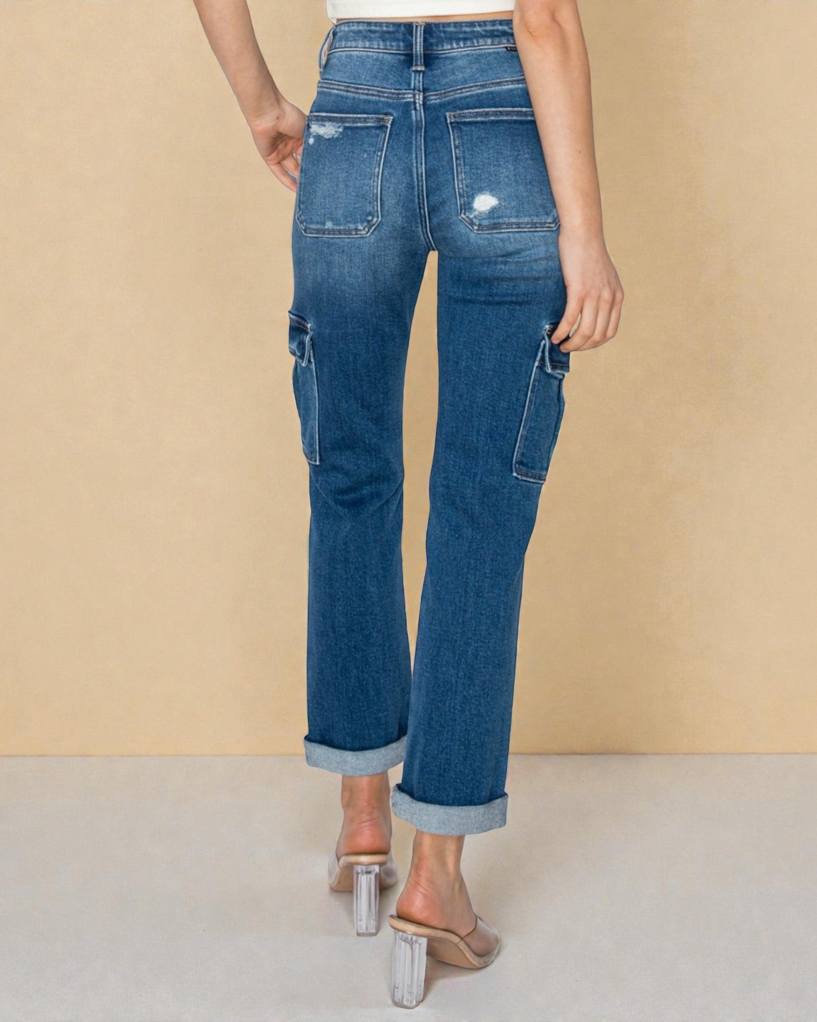 Person wearing blue jeans on a beige background