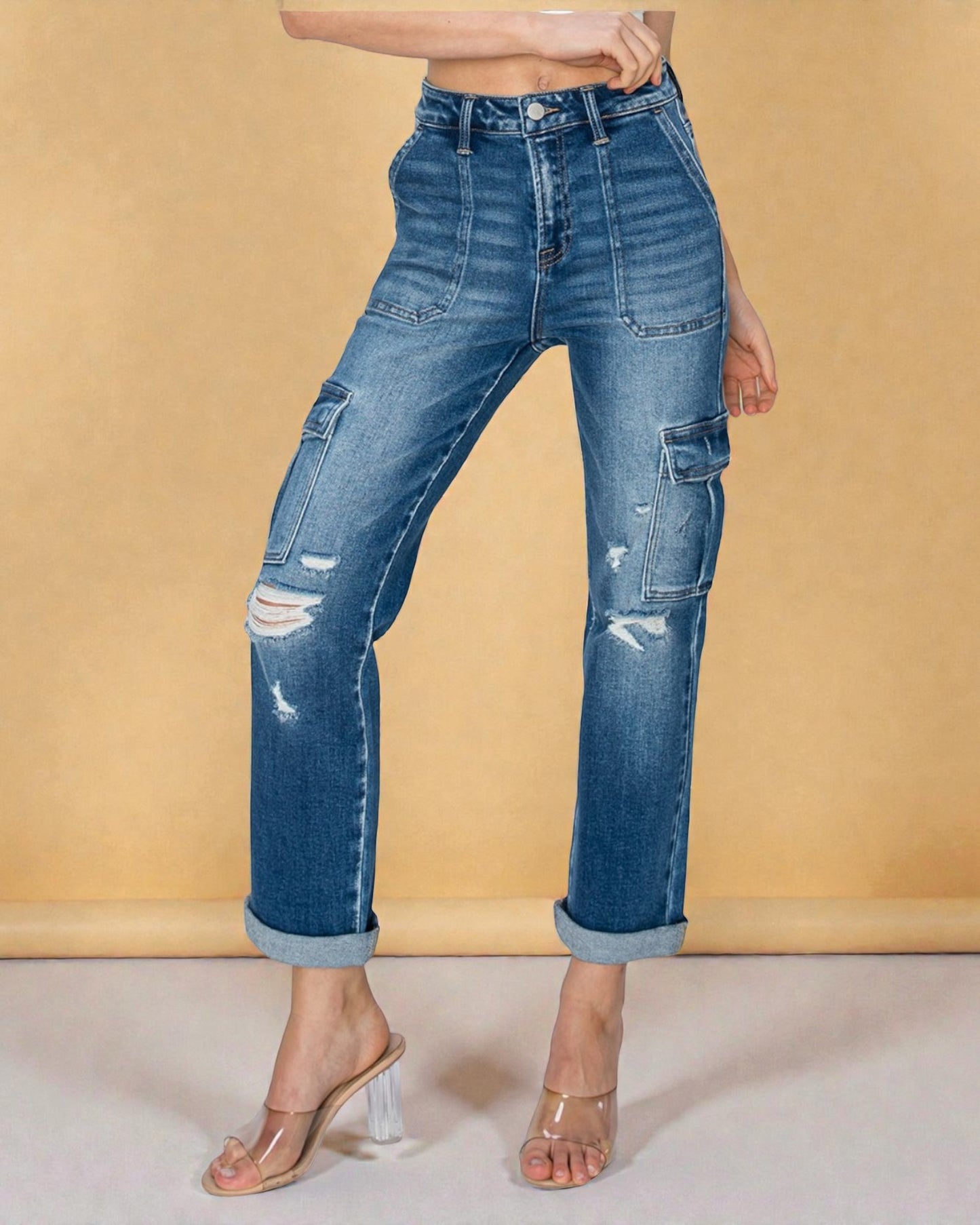 Blue jeans with distressing details on a beige background