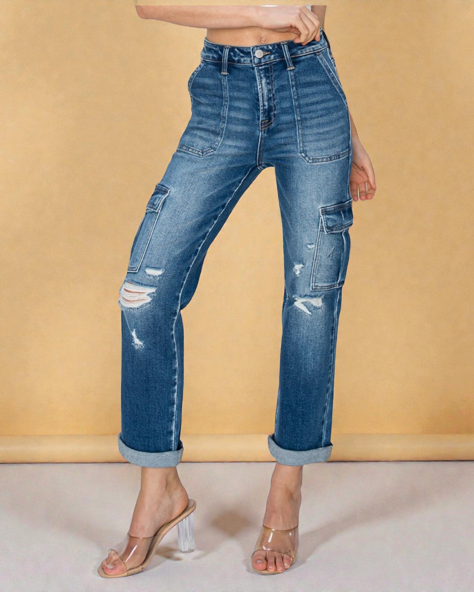 Blue jeans with distressing details on a beige background