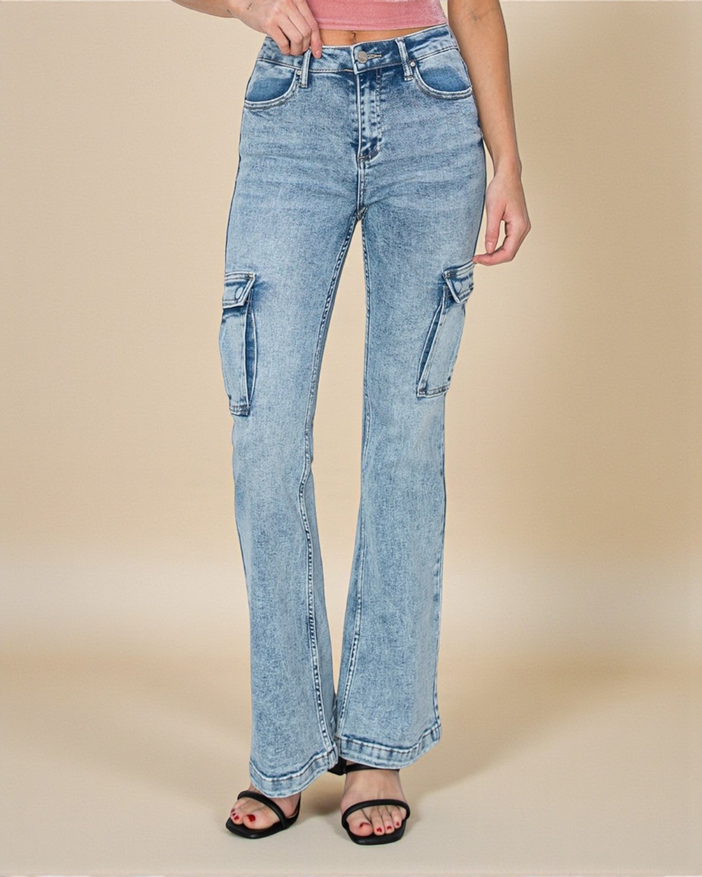 Light blue flared jeans worn by a person on a beige background