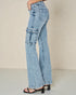 Light blue flared jeans worn by a person on a beige background