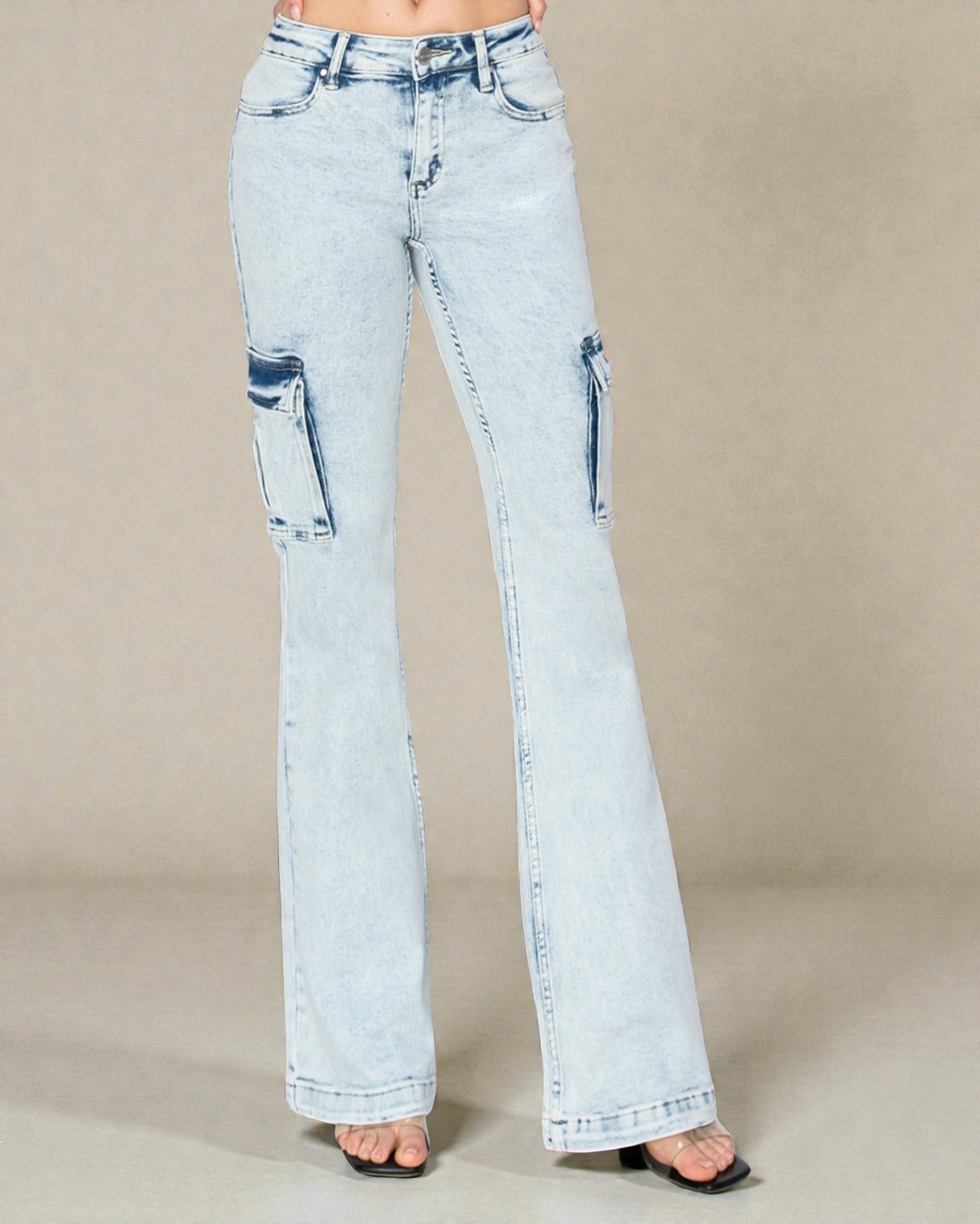 Light blue jeans with distressed details on a beige background