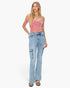 A woman modeling a pink off-the-shoulder crop top and light-wash blue high-rise cargo flare jeans against a plain white background.