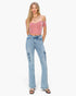 A woman modeling a dusty pink off-the-shoulder velvet crop top and light-wash blue high-rise flare jeans with cargo pockets, paired with black slide sandals, against a plain white background.
