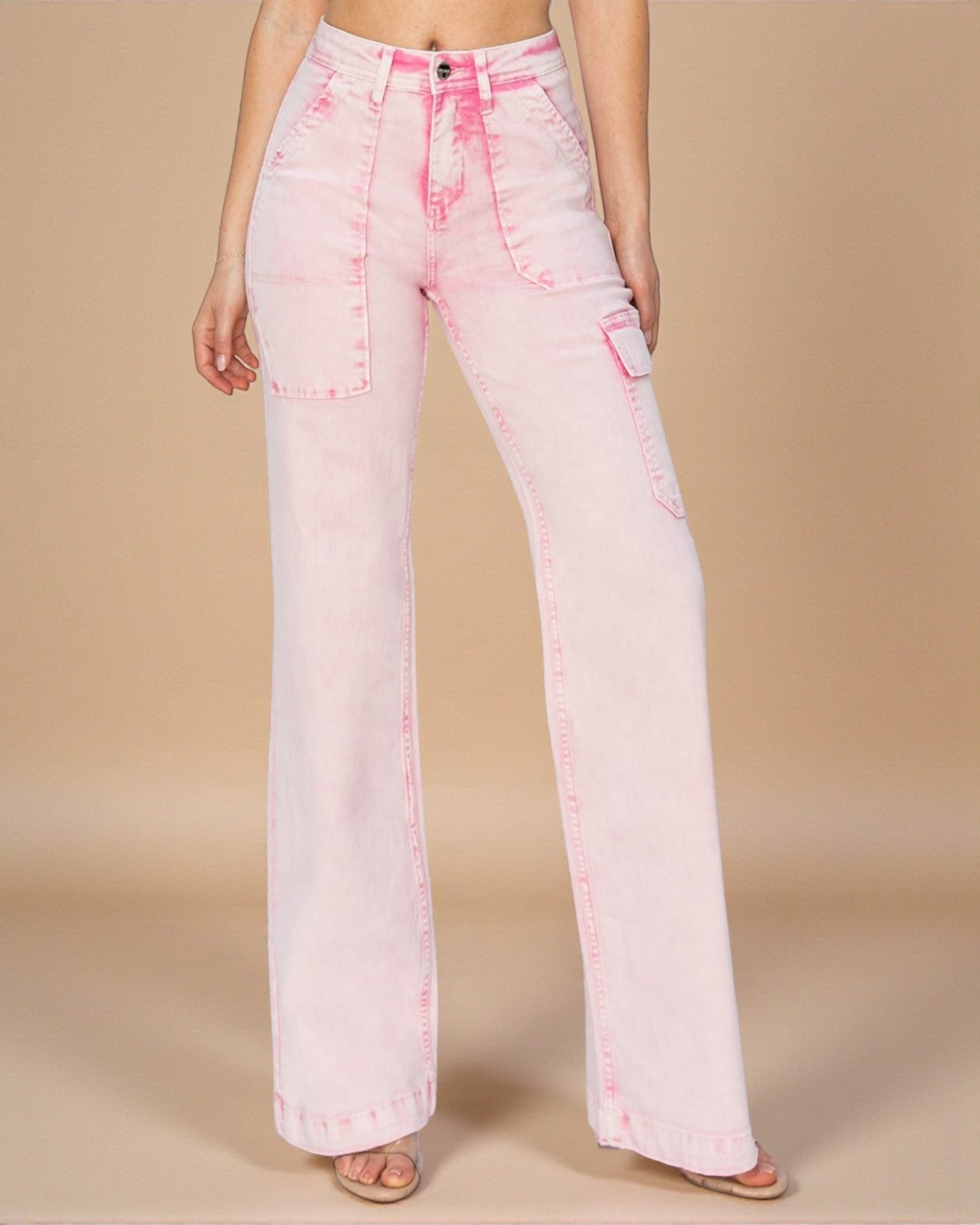 Pink acid-wash jeans worn by a person on a beige background