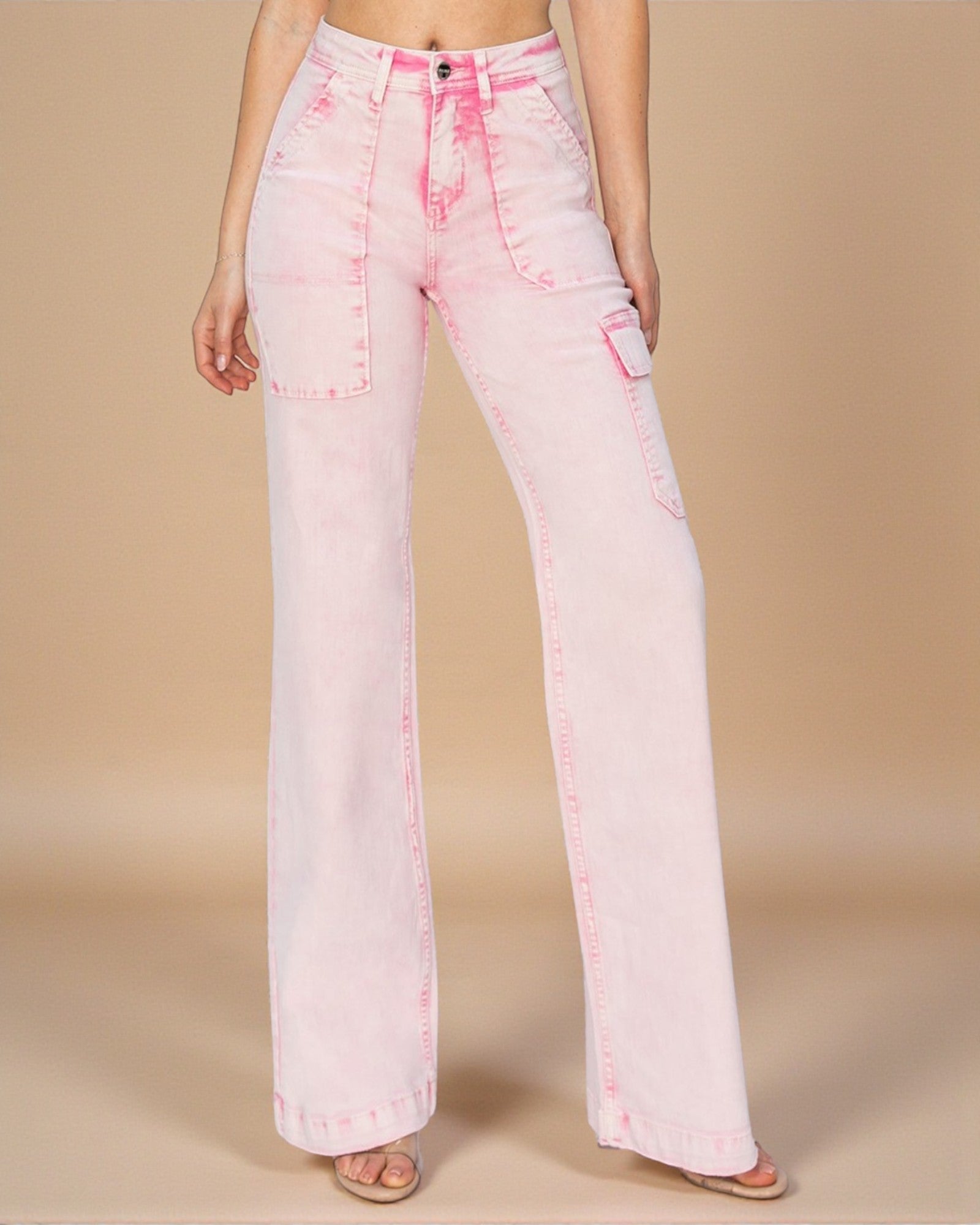 Pink acid-wash jeans worn by a person on a beige background