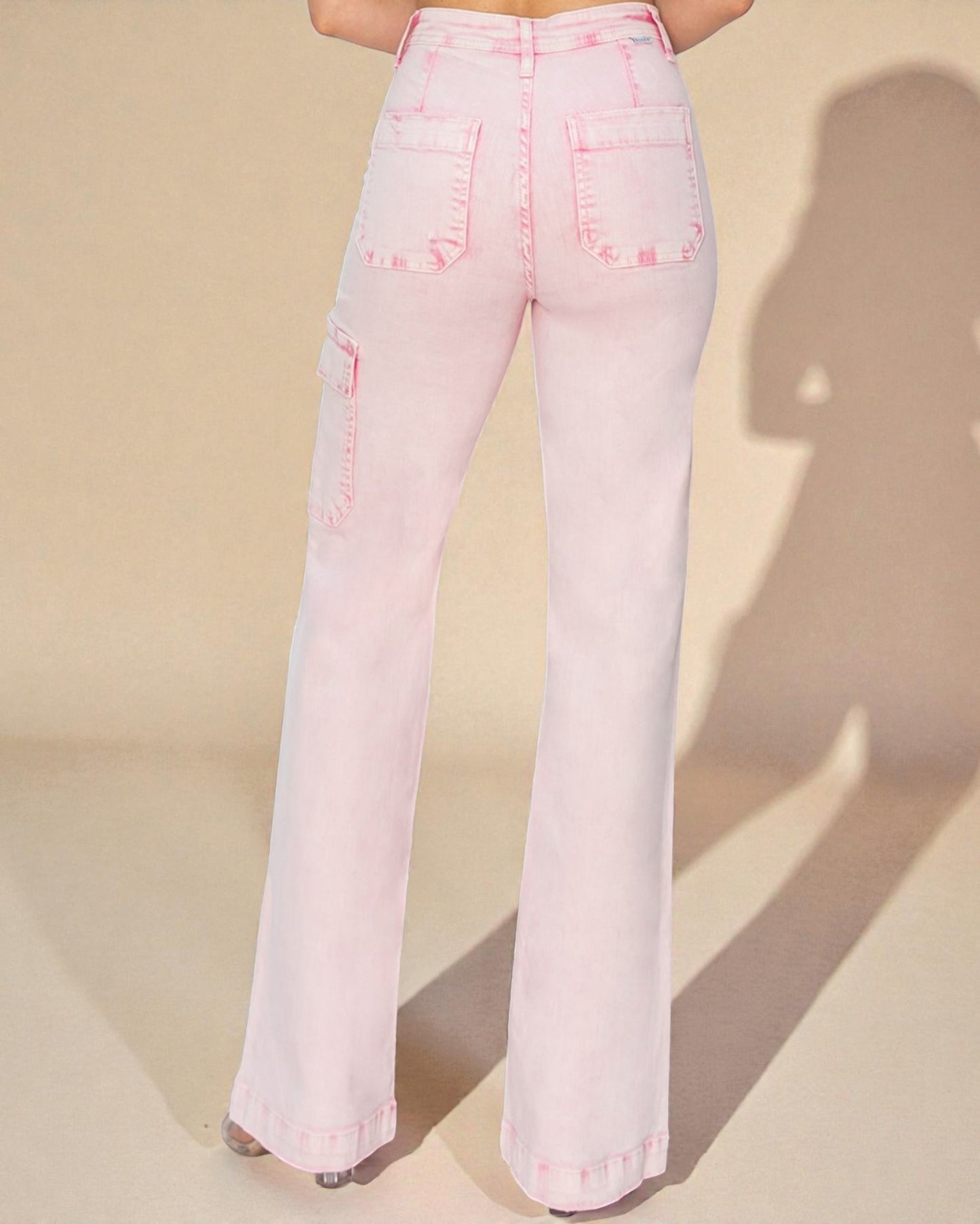 Pink flared jeans on a beige background