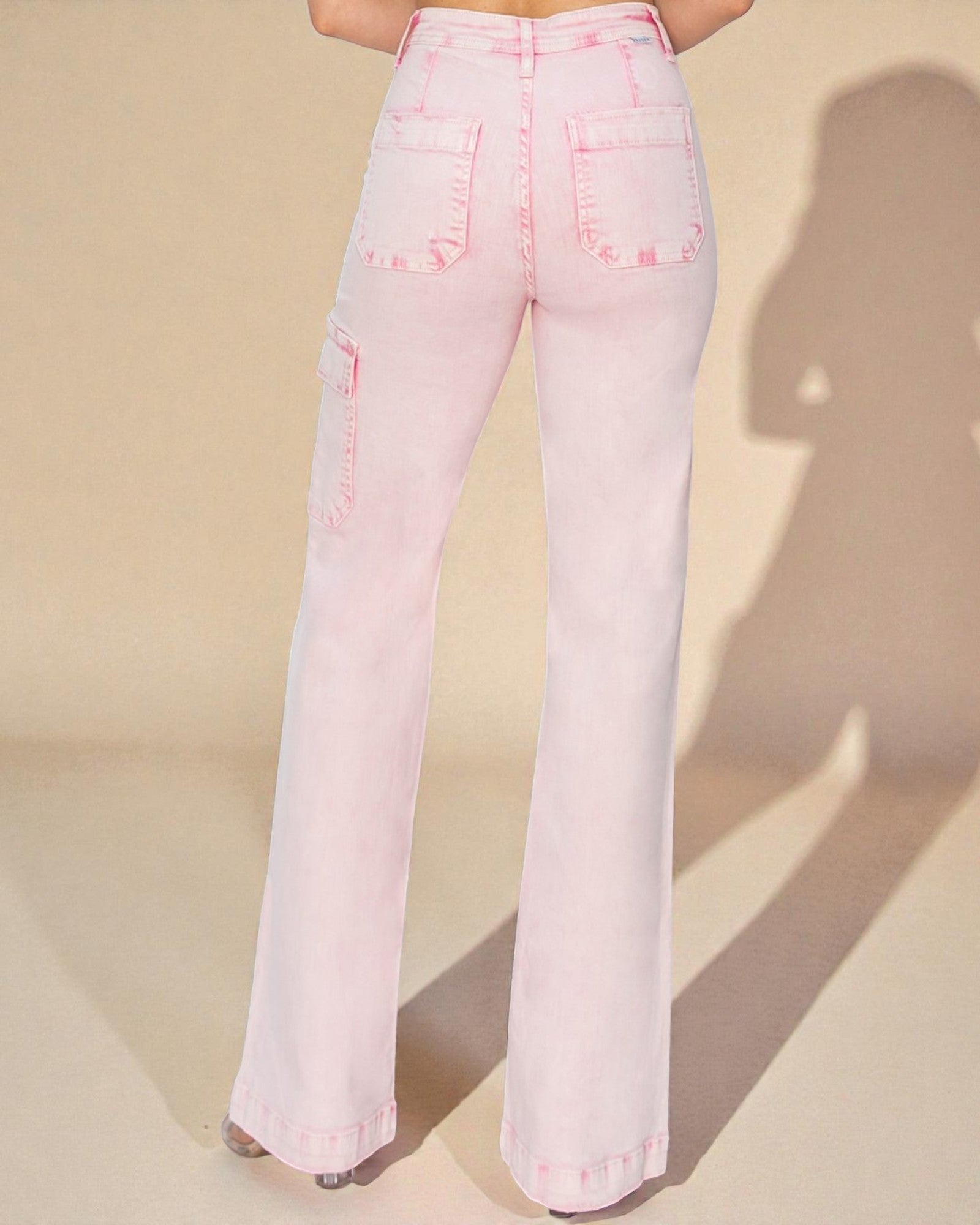 Pink flared jeans on a beige background