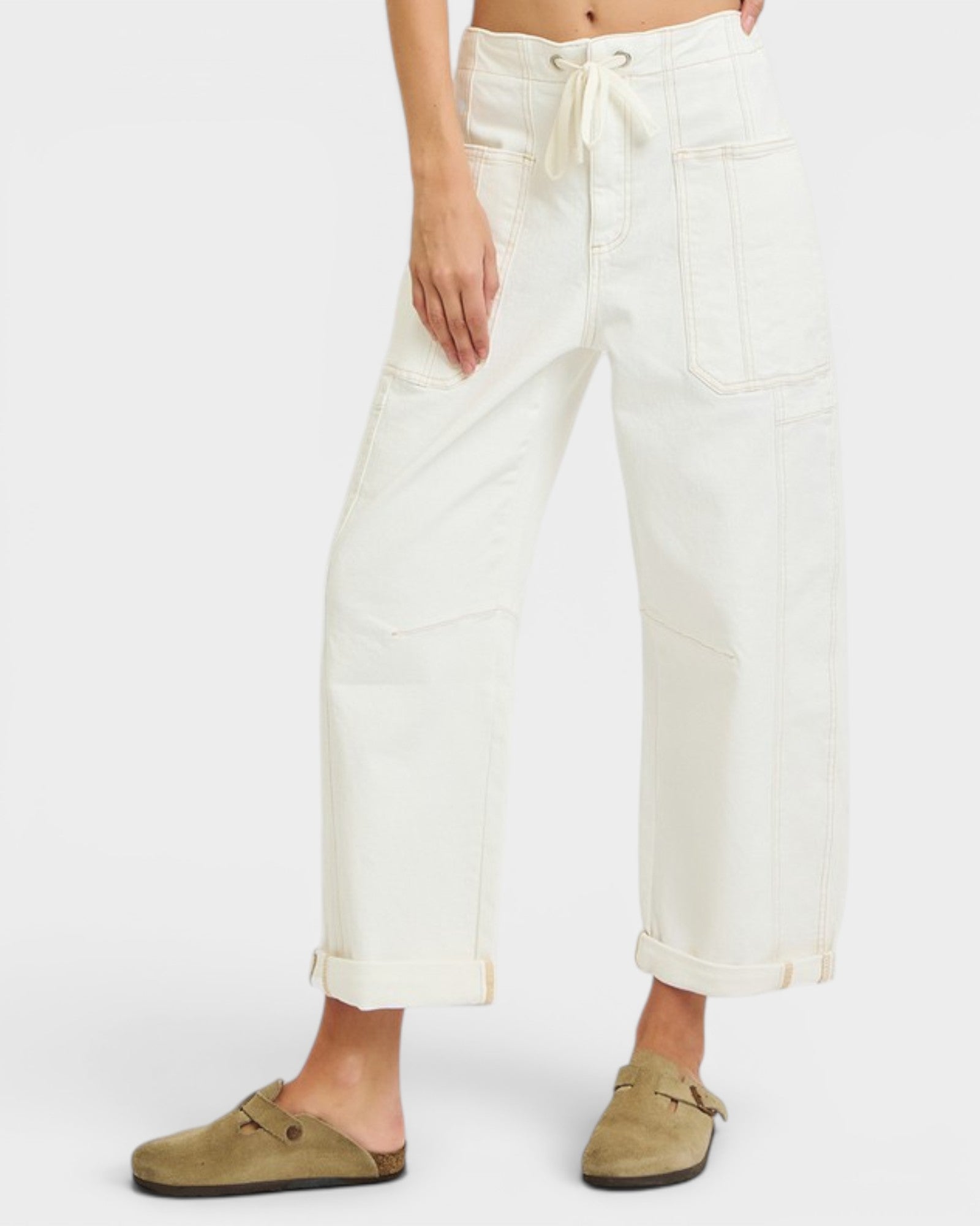 Person wearing white pants with a plain background