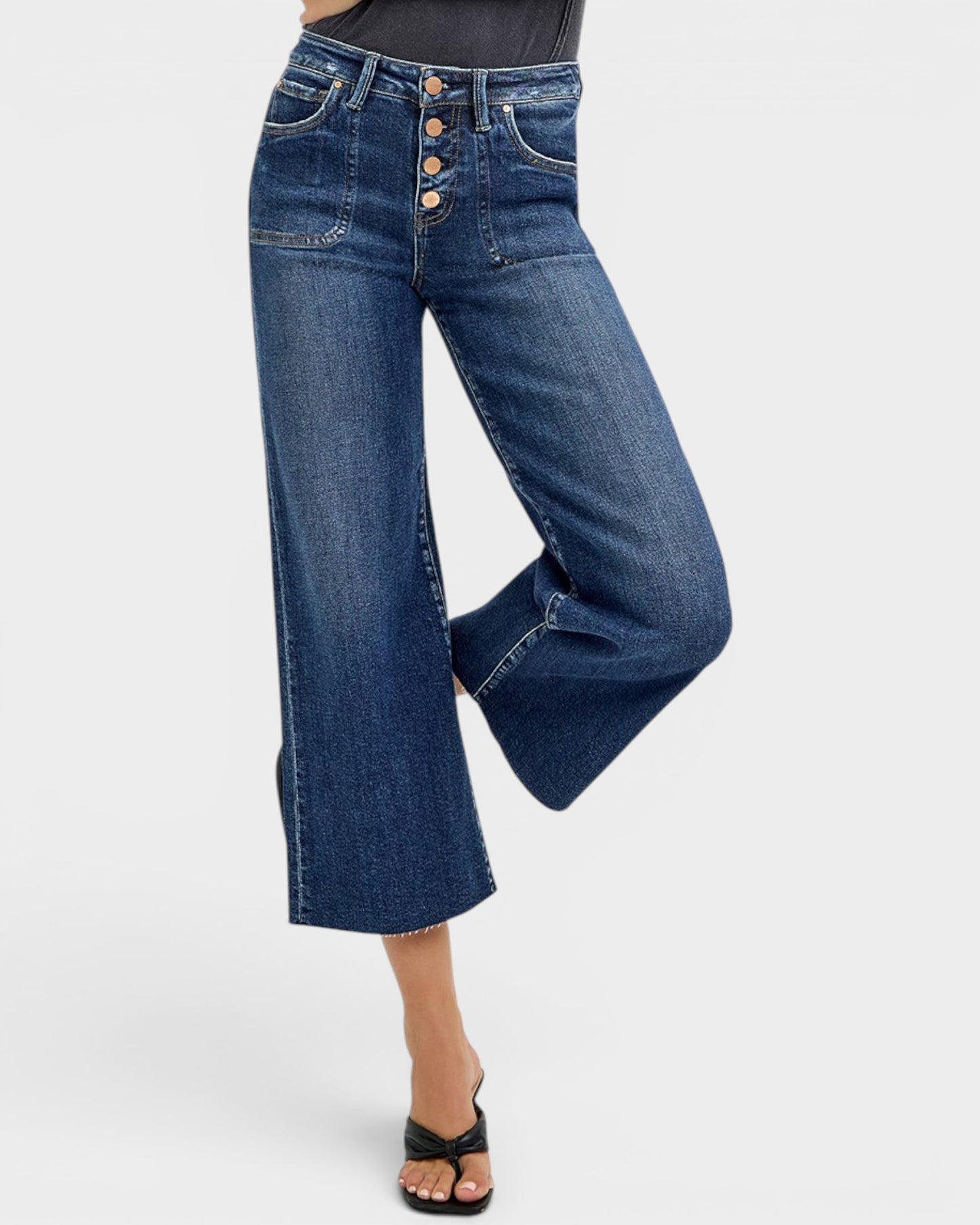 Blue wide-leg jeans worn by a person on a white background