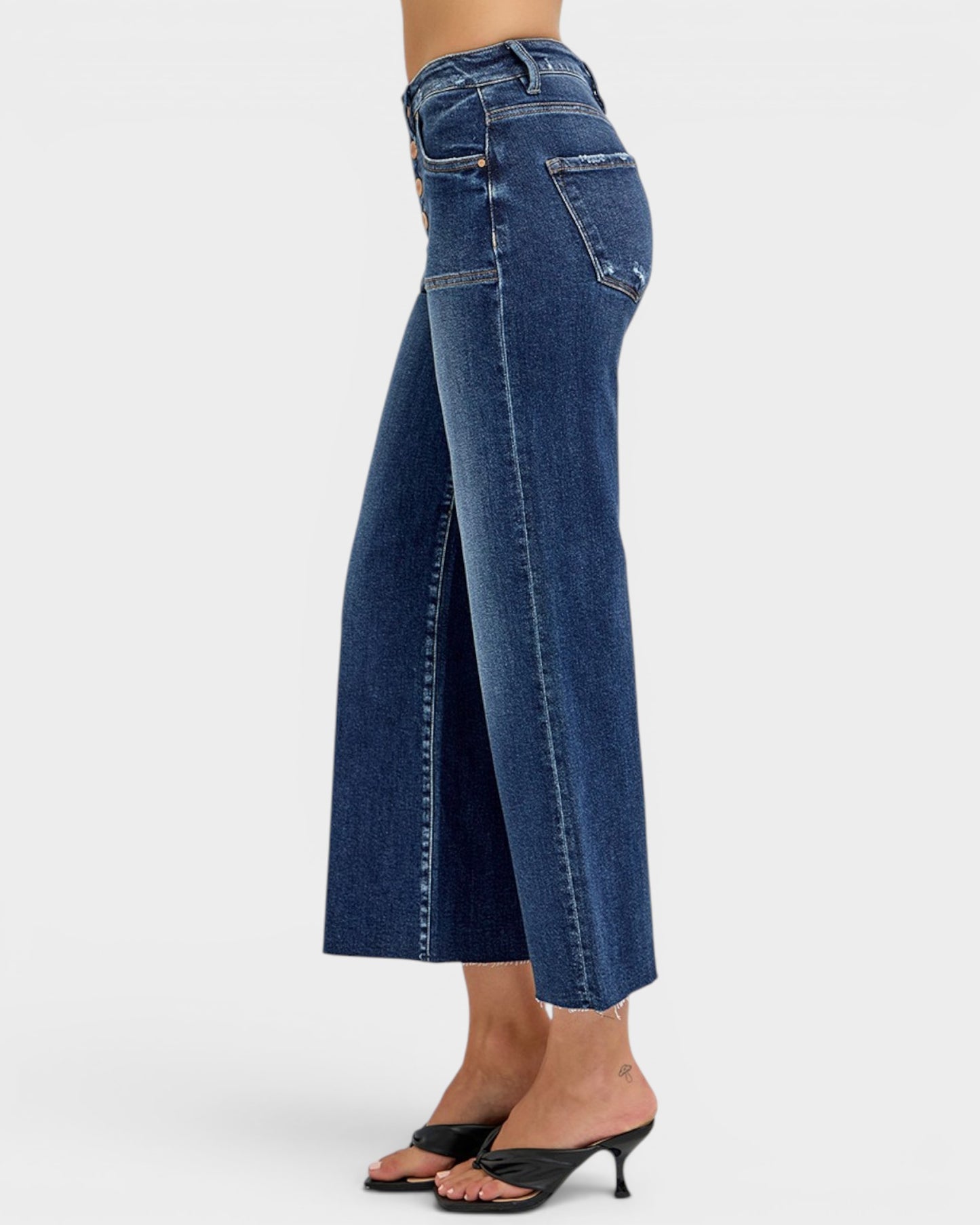 Blue wide-leg jeans worn by a person on a white background