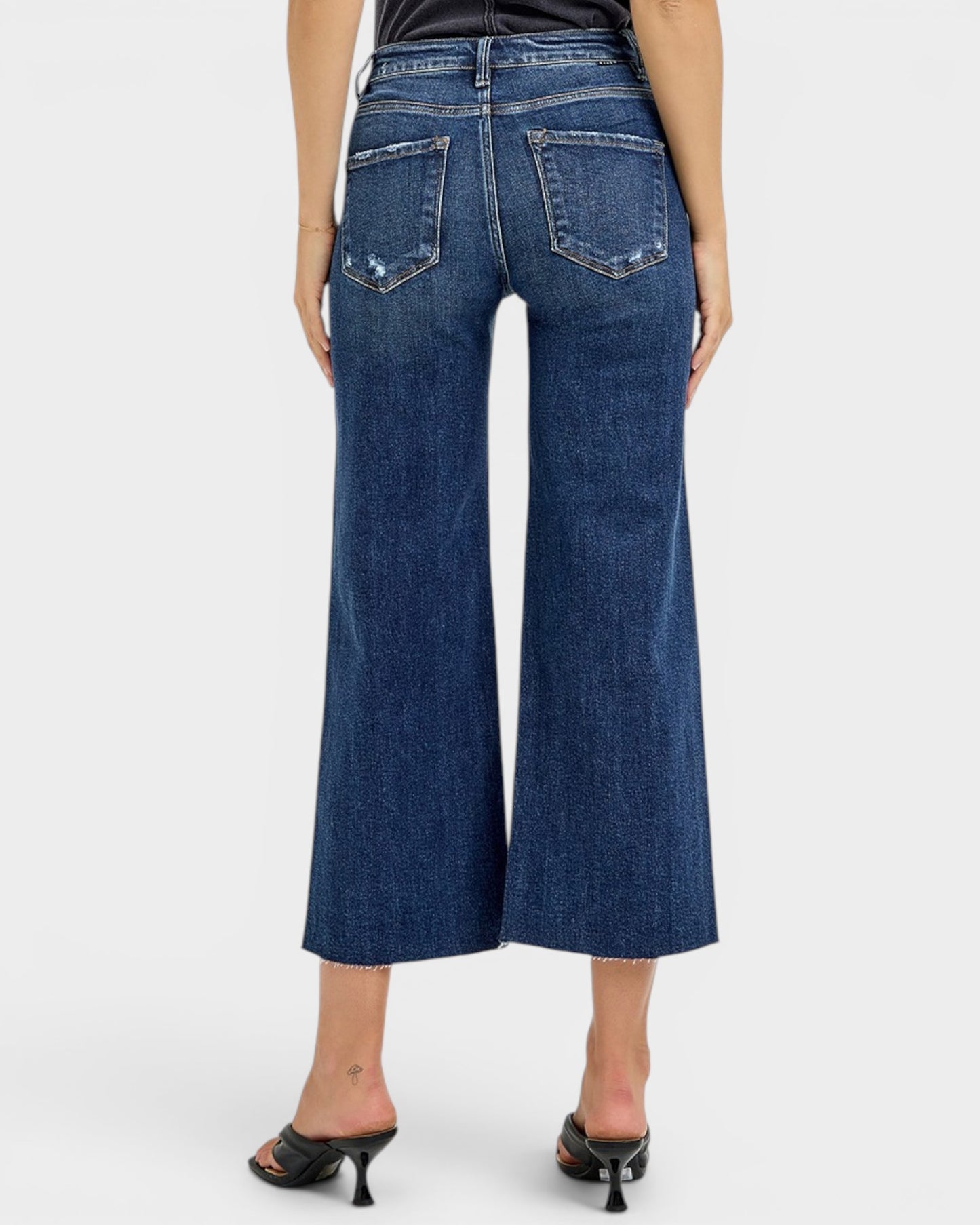 Blue jeans worn by a person on a white background