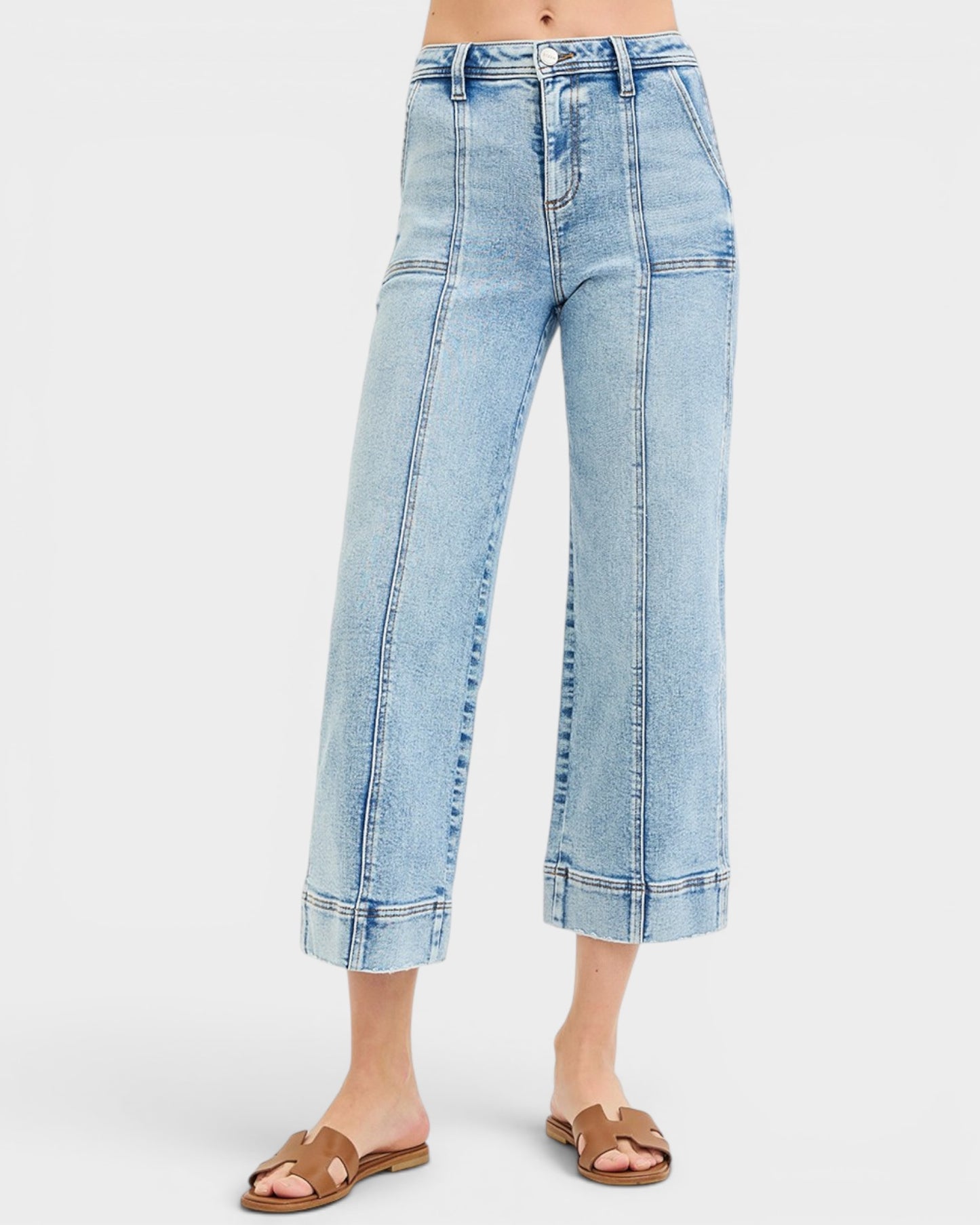 Light blue denim jeans worn by a person on a white background