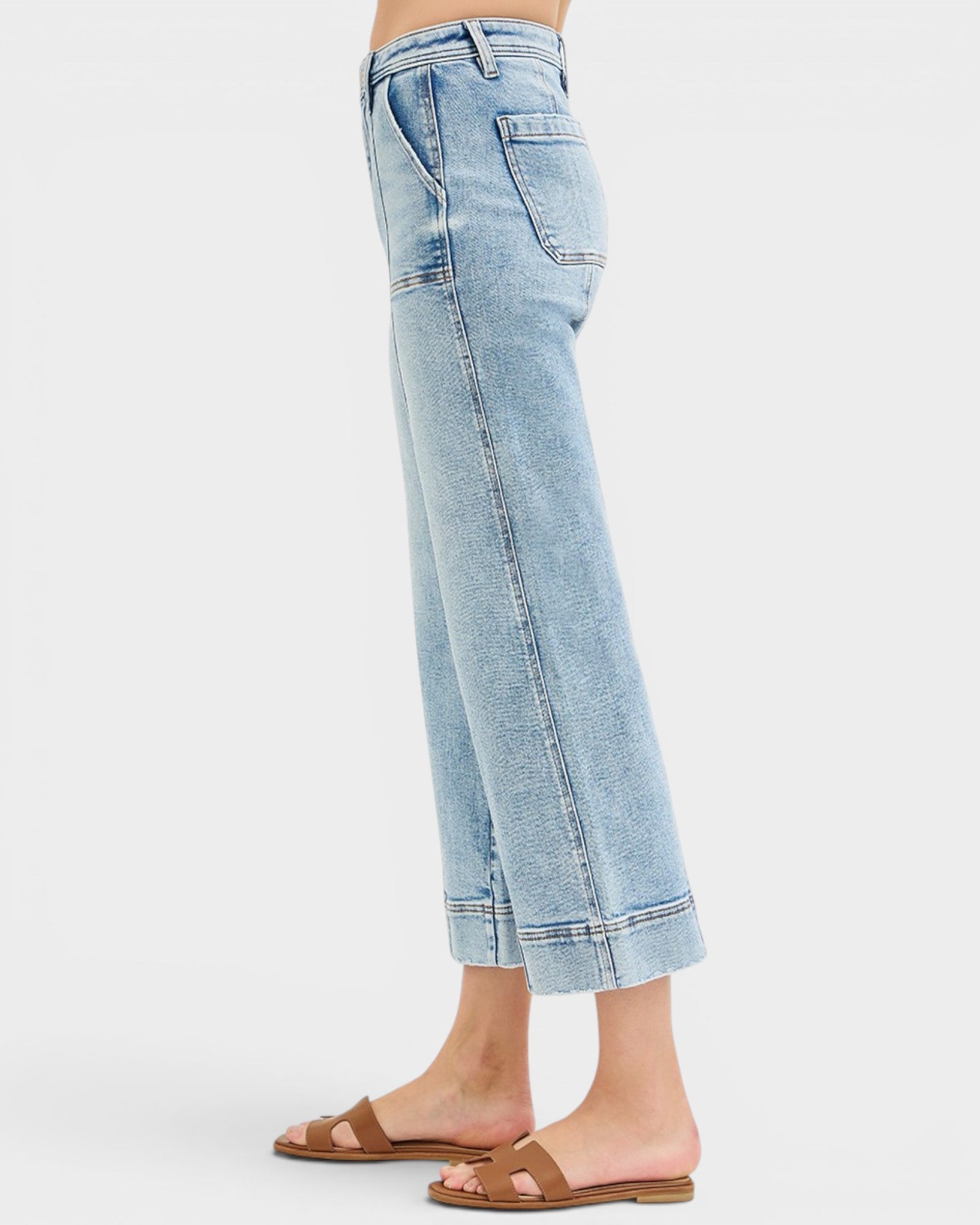 Light blue jeans worn by a person on a white background