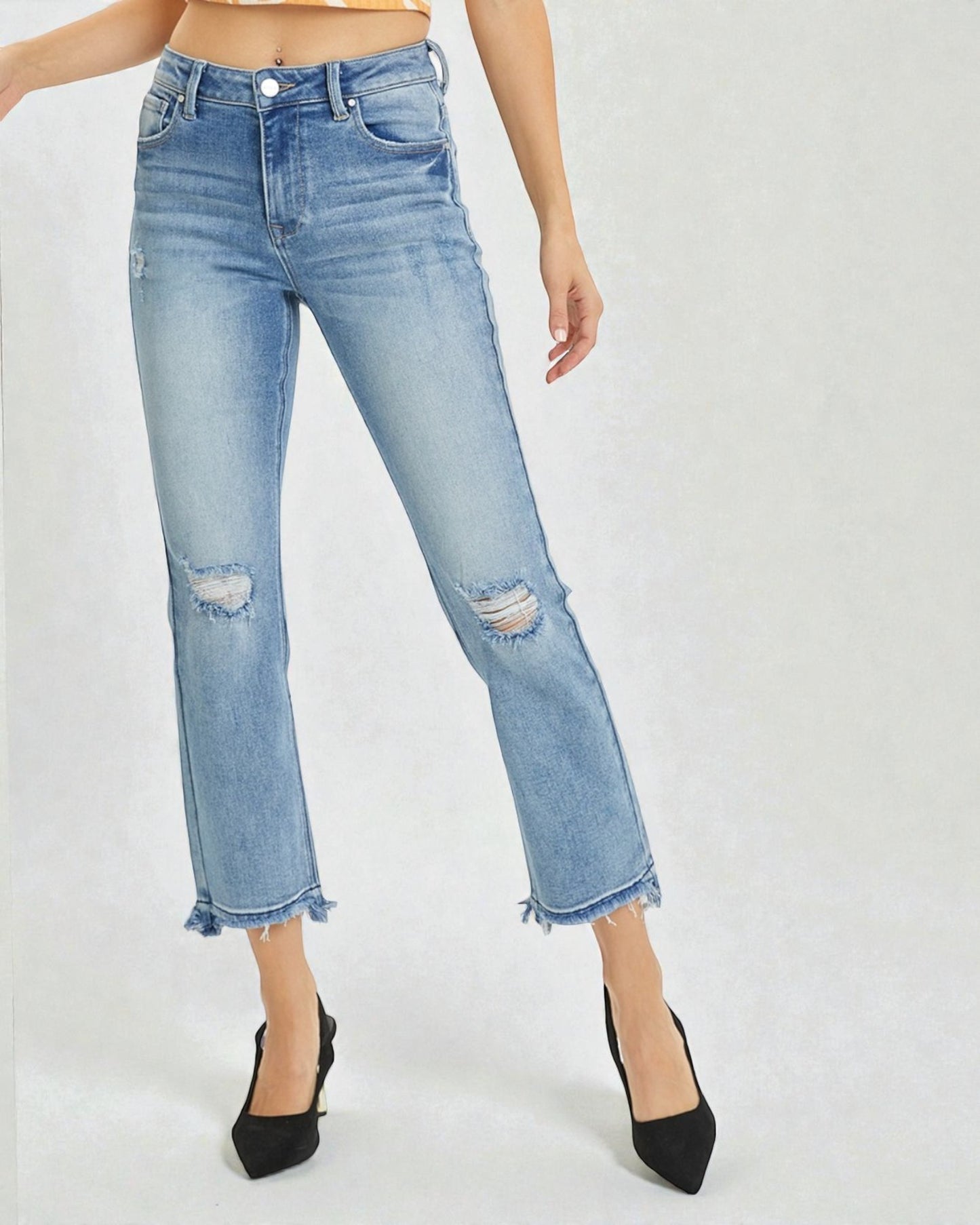 Light blue distressed jeans worn by a person on a white background