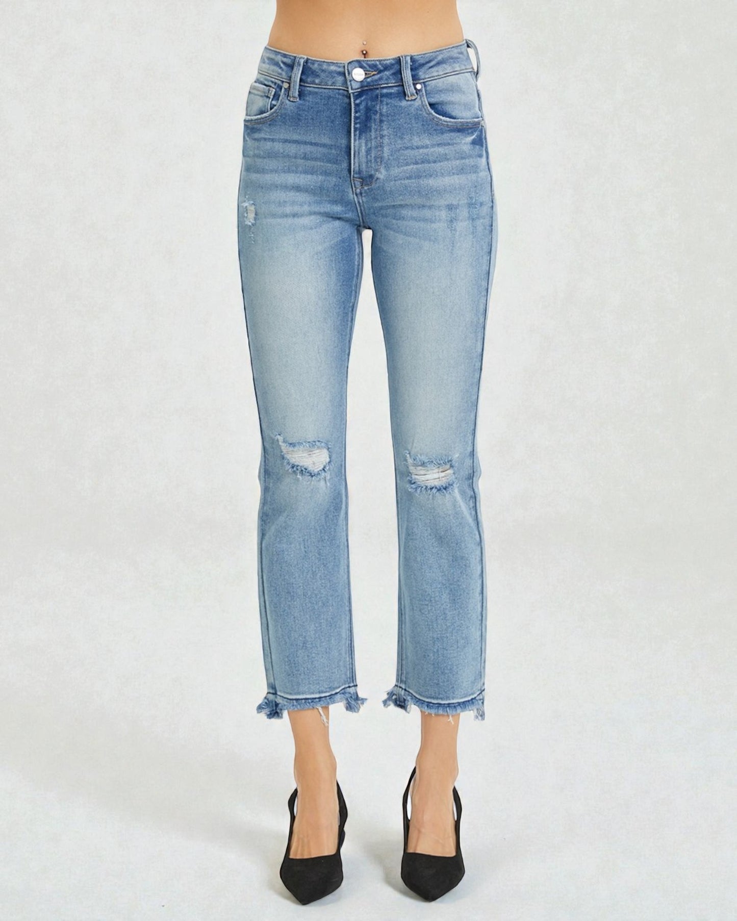 Light blue jeans with distressed details on a white background