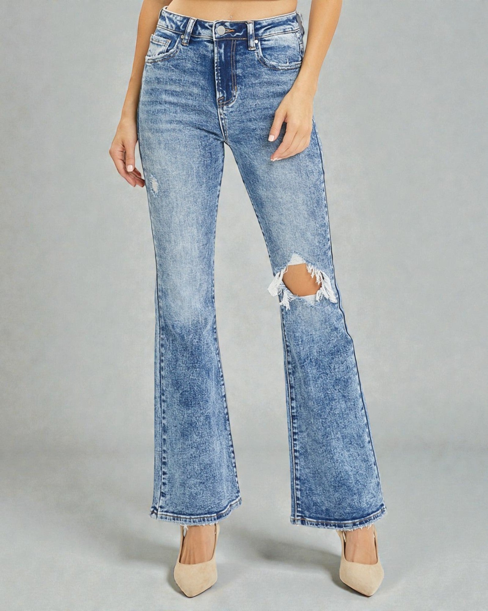 Blue jeans with a distressed design on a gray background