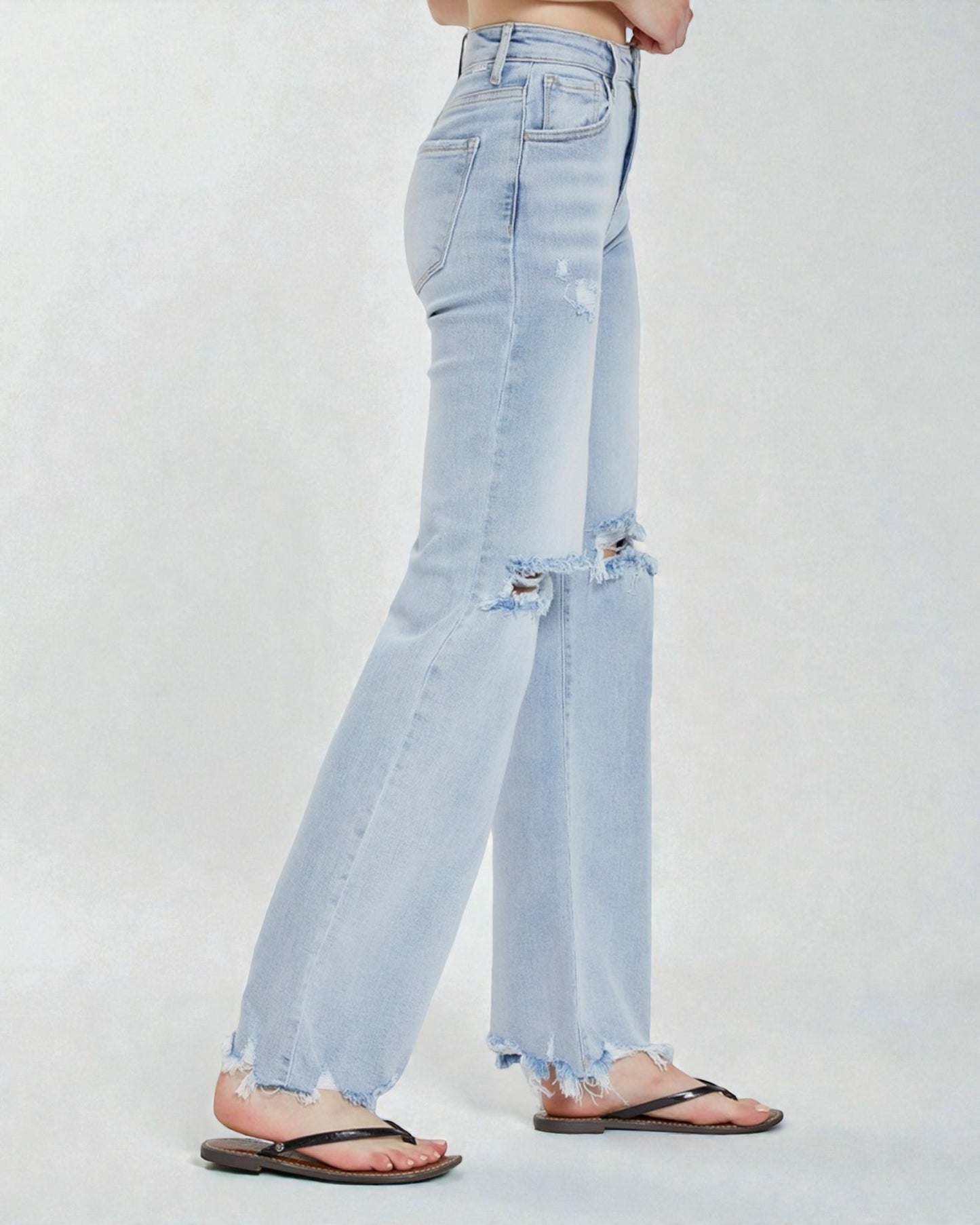 Light blue jeans with frayed hems on a white background