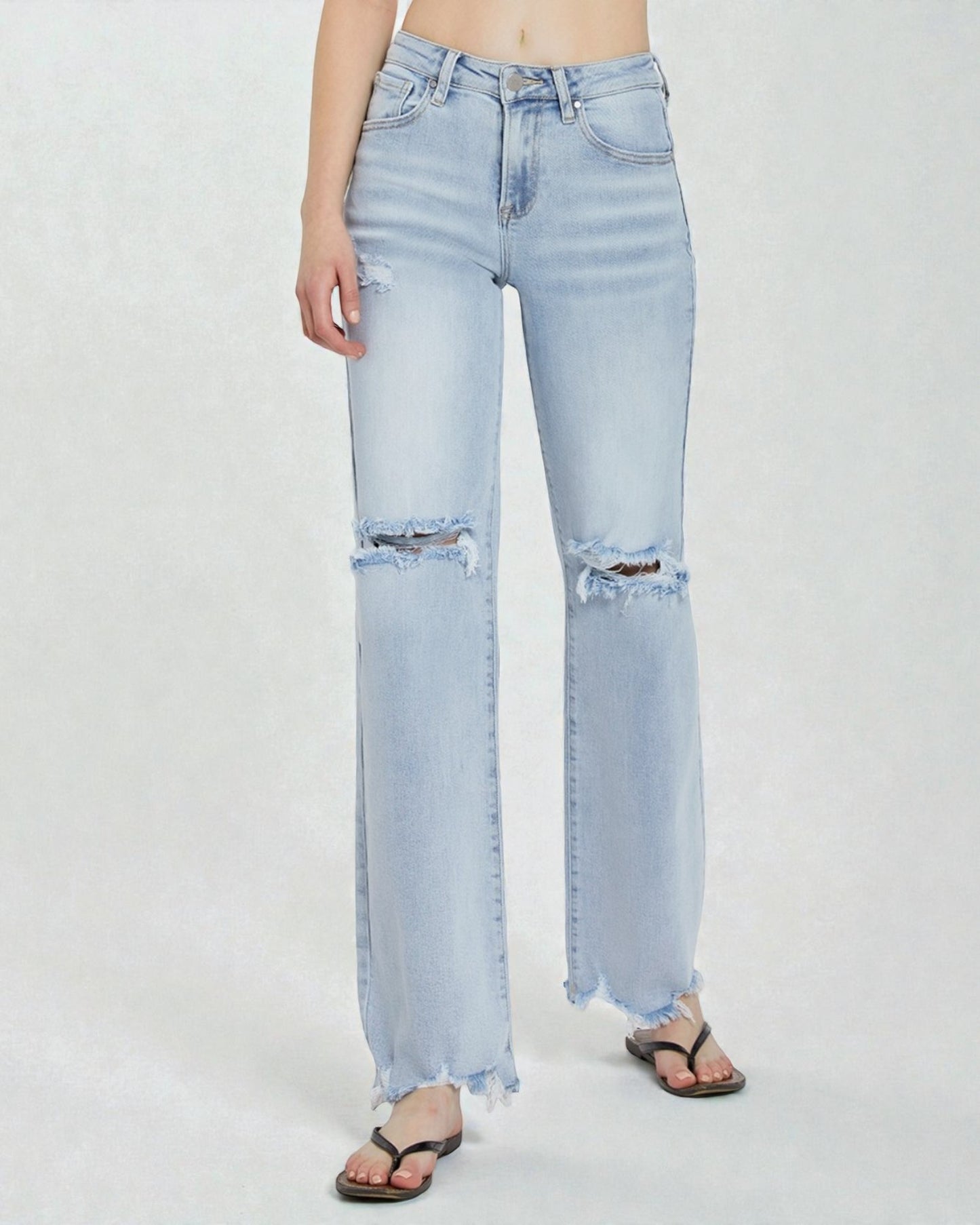 Light blue jeans with frayed hems on a white background