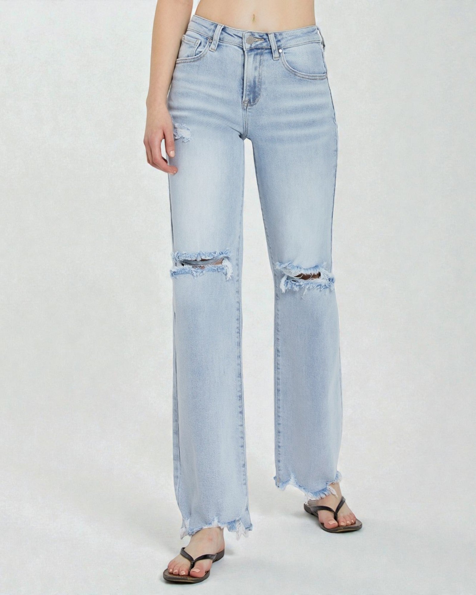Light blue jeans with frayed hems on a white background