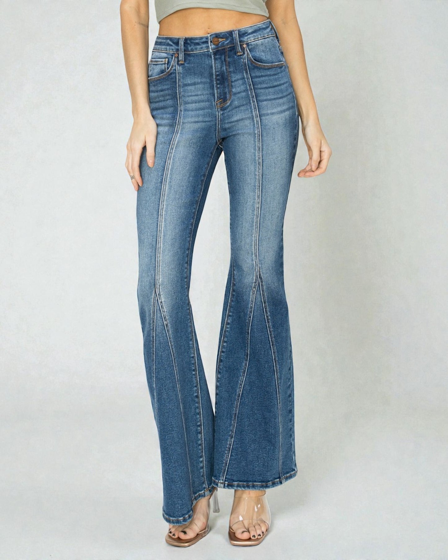 Blue flared jeans worn by a person on a white background