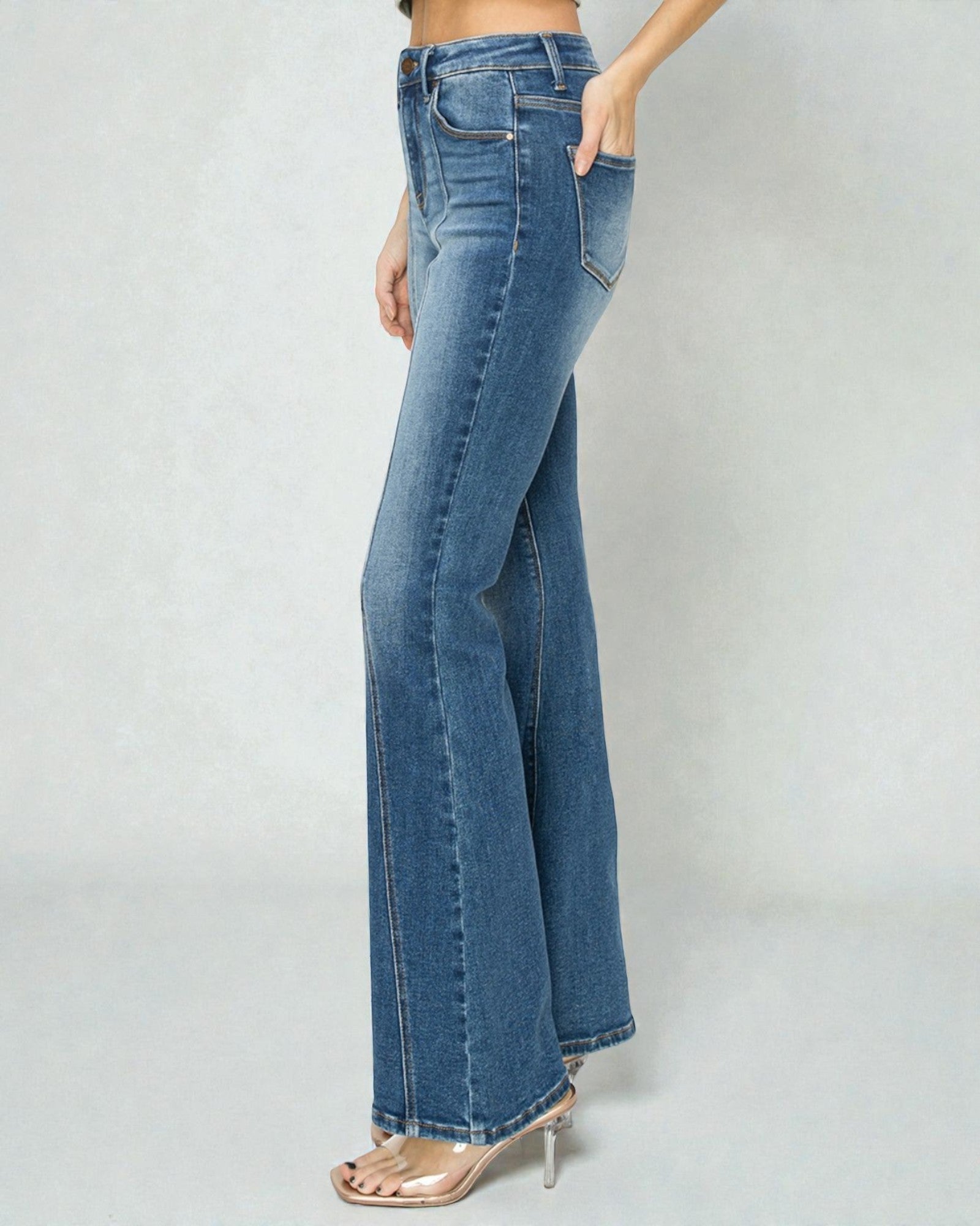 Blue jeans worn by a person on a plain background