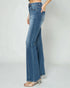 Blue jeans worn by a person on a plain background