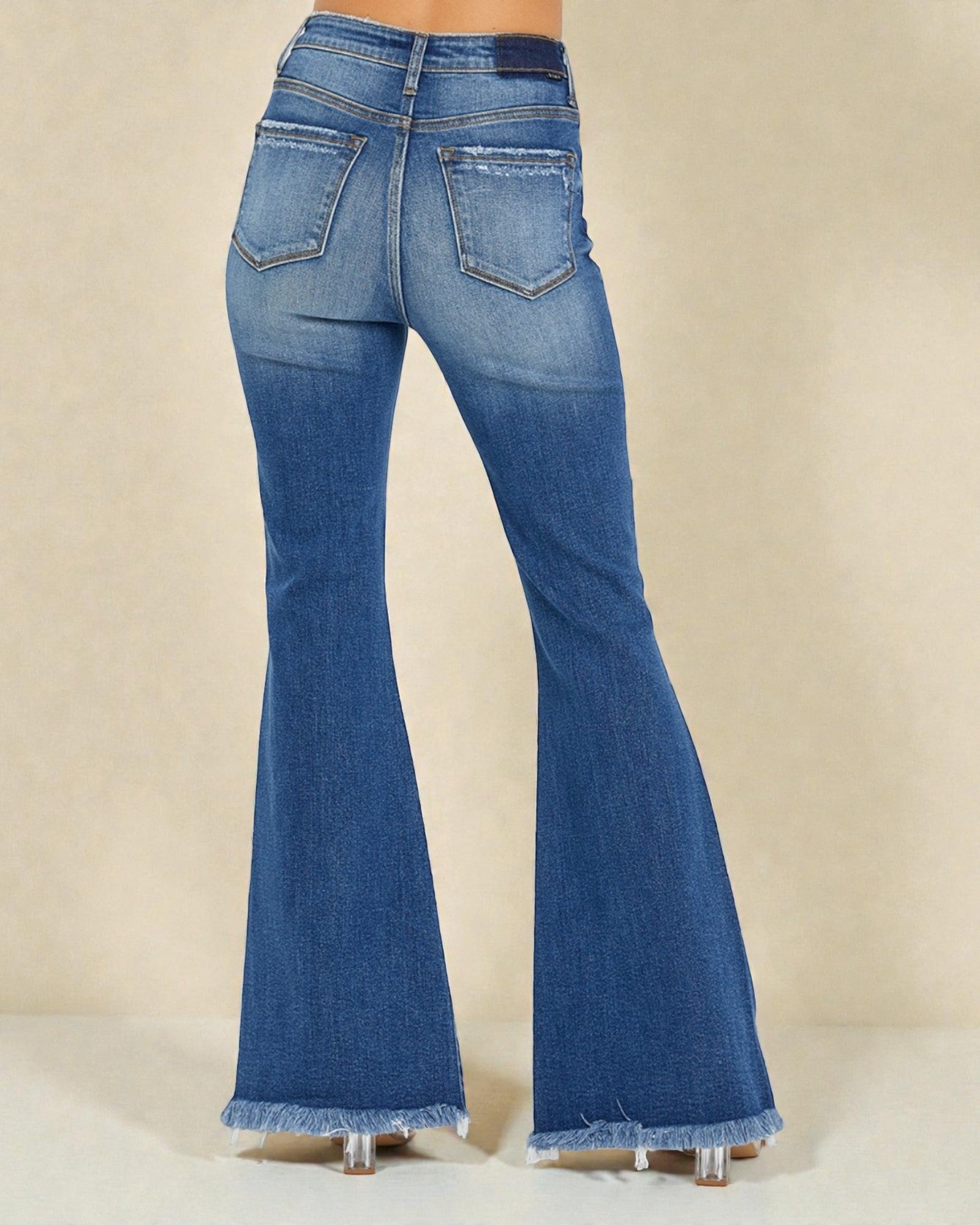 Blue flared jeans on a beige background