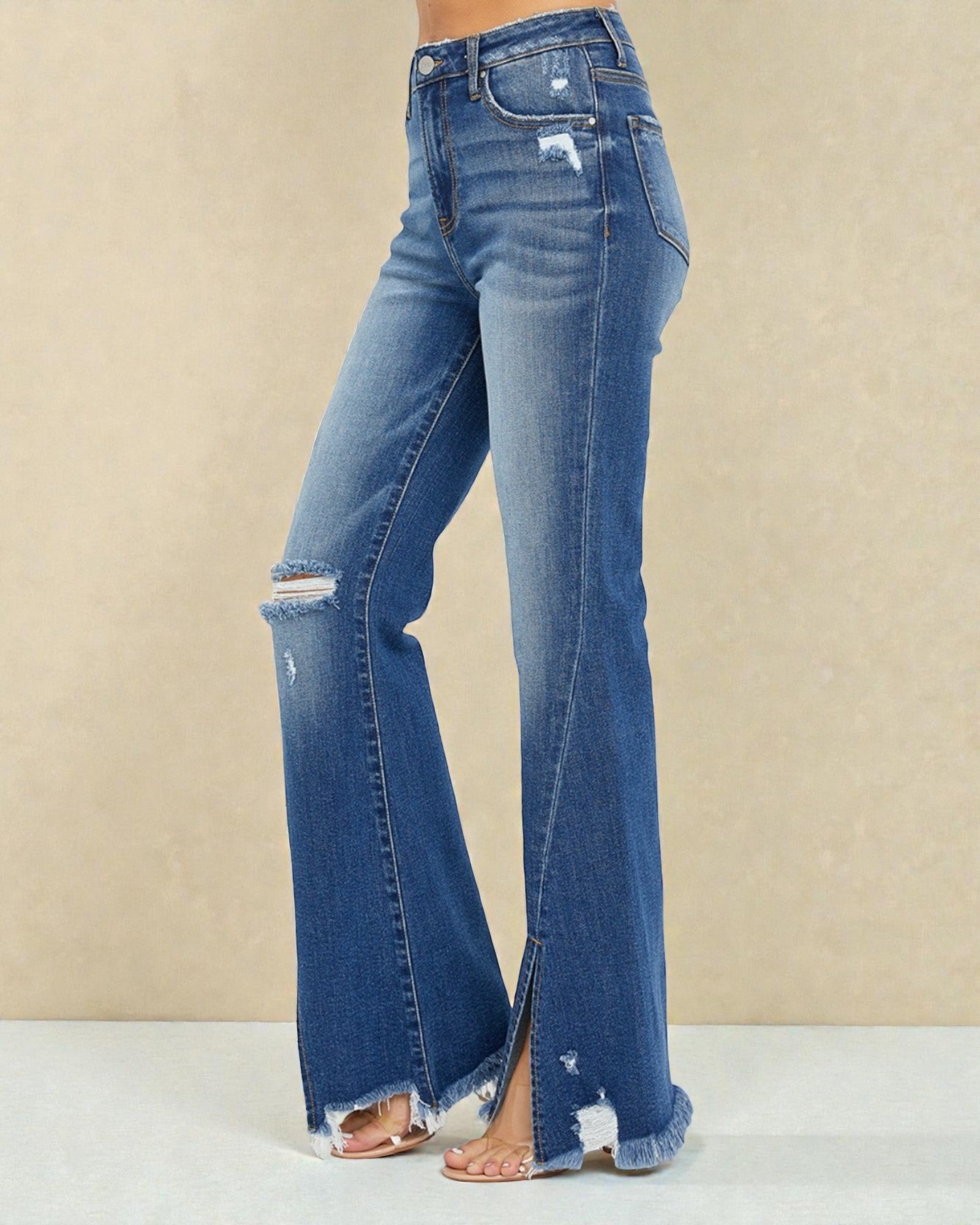 Blue jeans with distressed details on a beige background