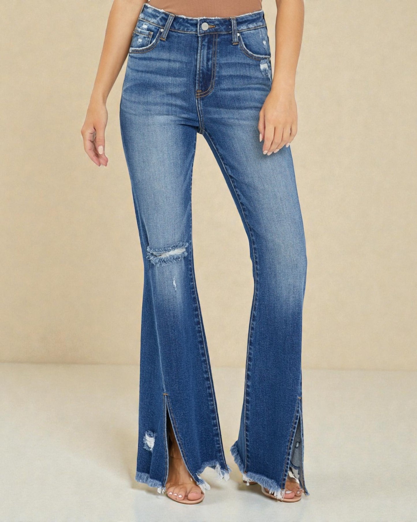 Blue flared jeans with a slit on a beige background