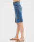 Blue denim skirt worn by a person on a white background