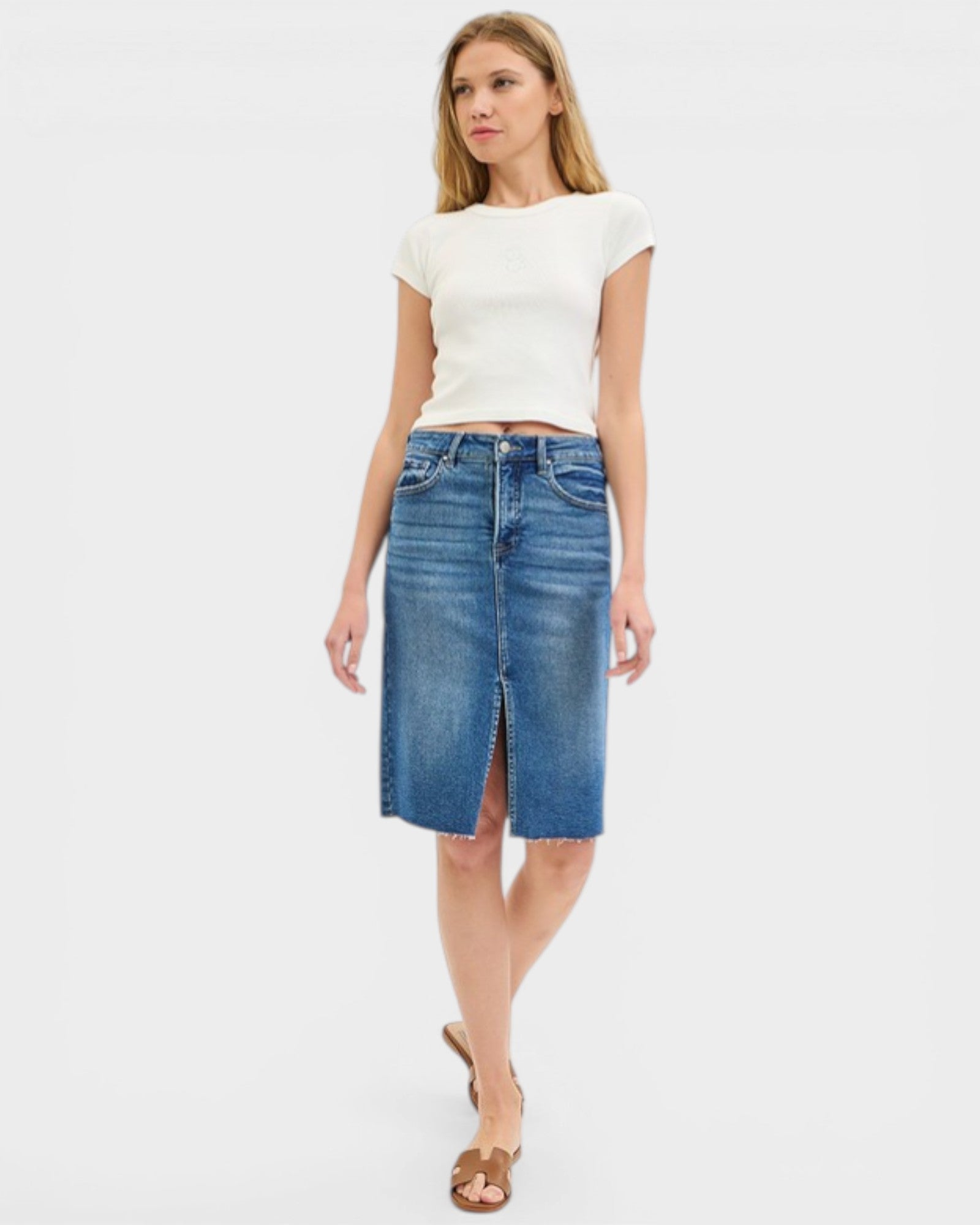 Woman wearing a white top and blue denim skirt on a white background