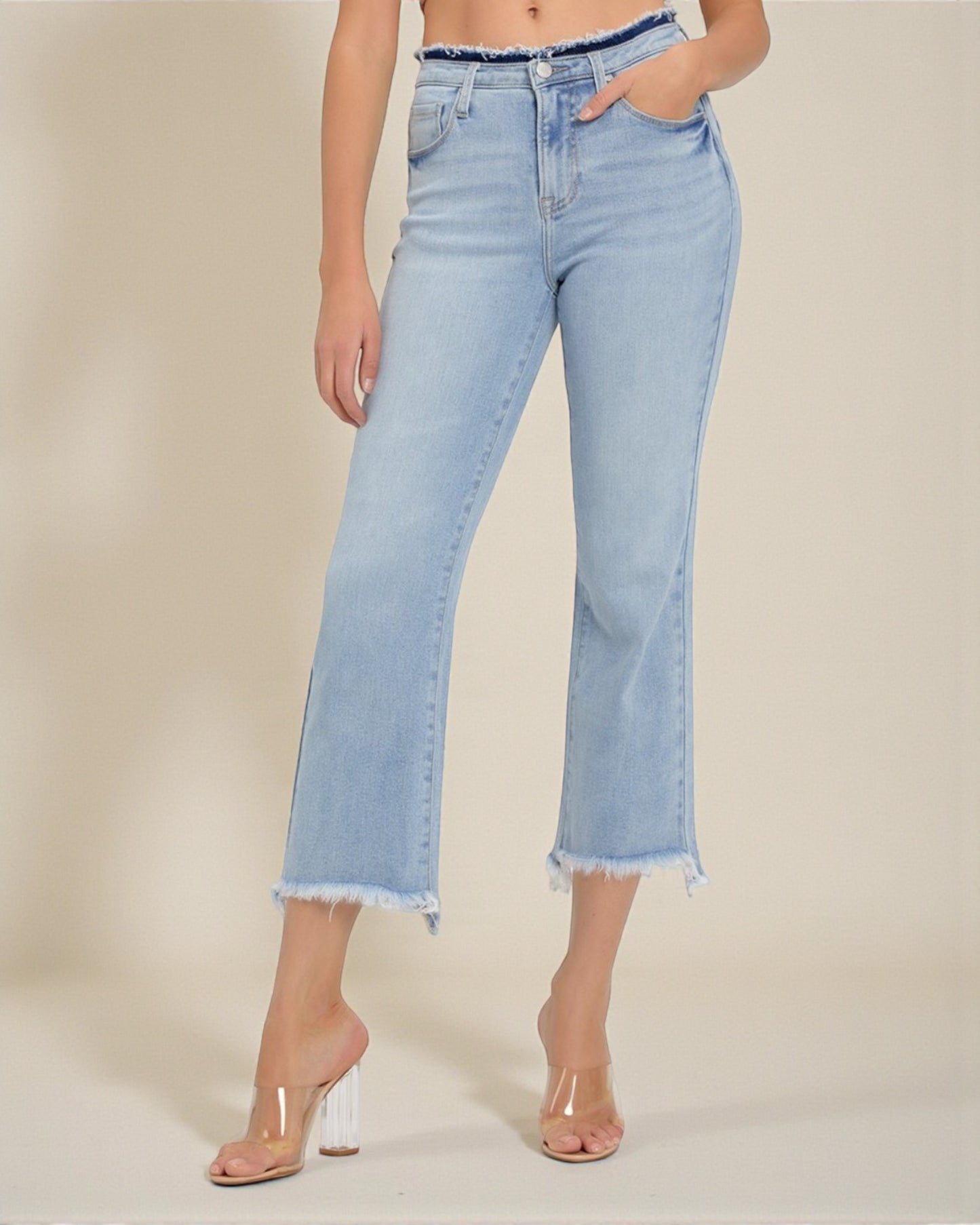 Light blue jeans worn by a person on a beige background