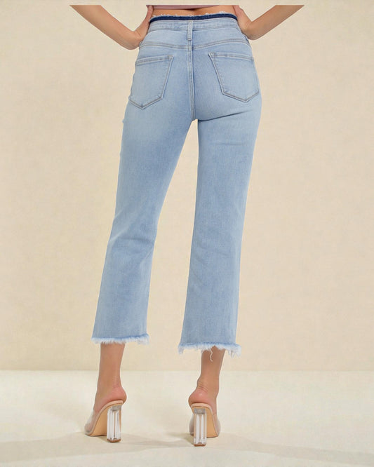 Light blue jeans worn by a person on a beige background