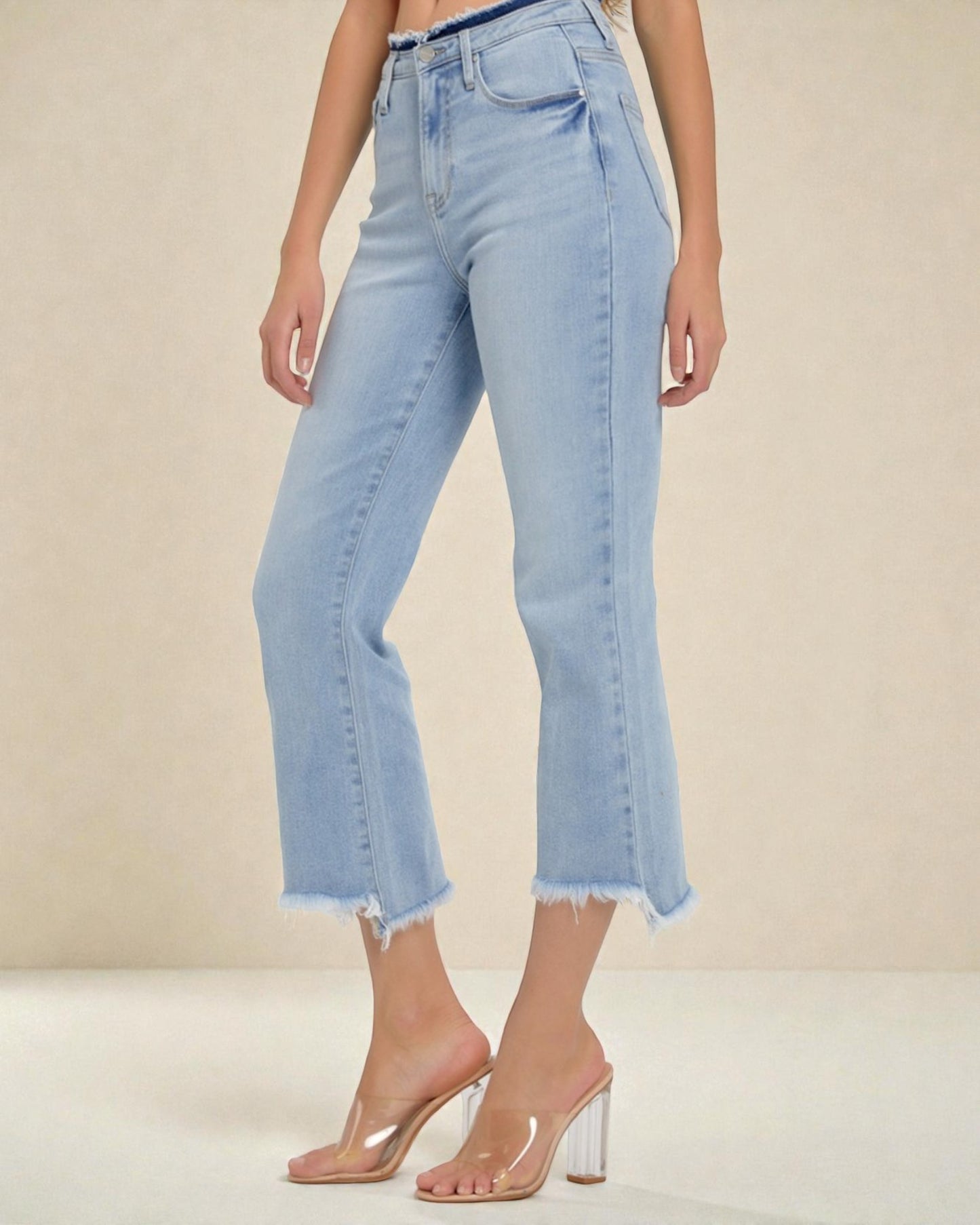 Light blue jeans worn by a person on a beige background