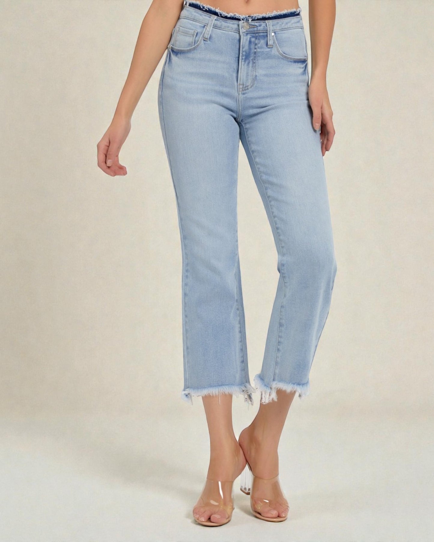 Light blue jeans worn by a person on a beige background