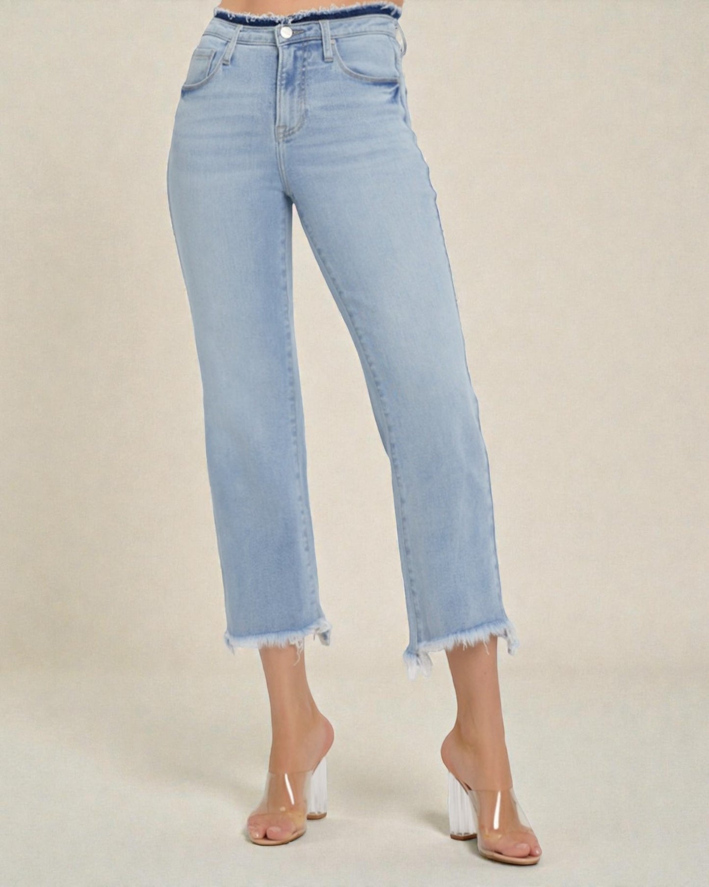 Light blue jeans worn by a person on a beige background