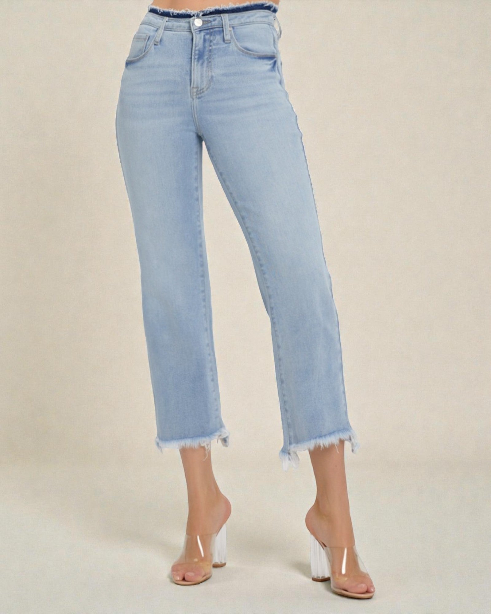 Light blue jeans worn by a person on a beige background