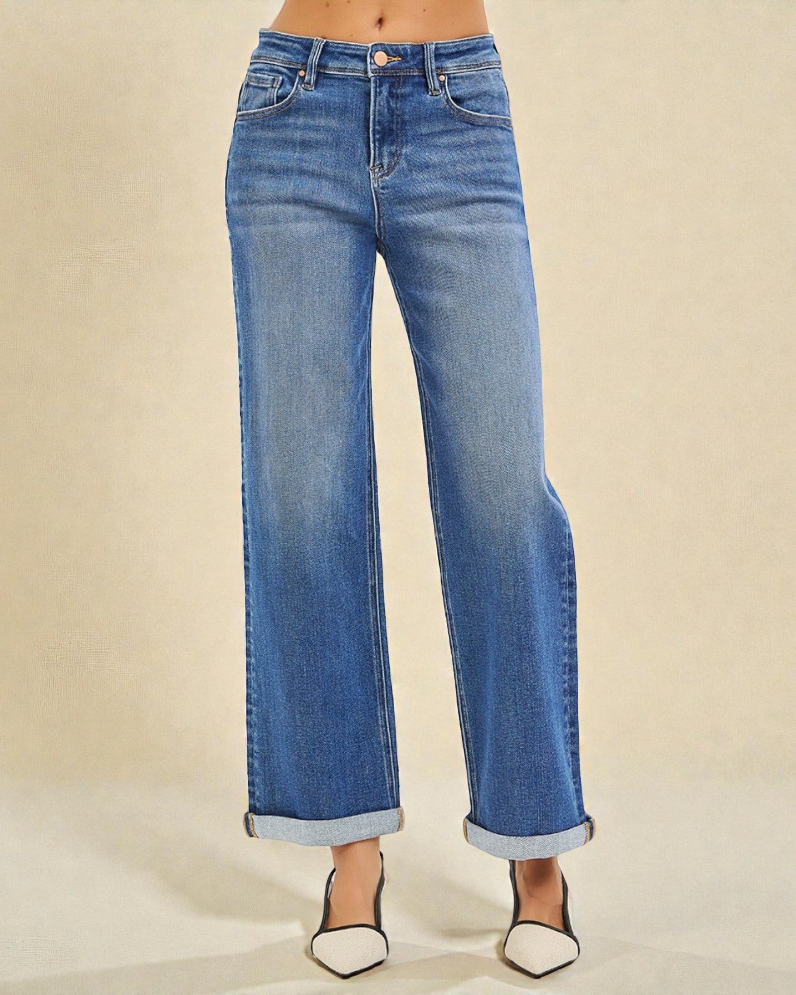 Blue jeans worn by a person on a beige background