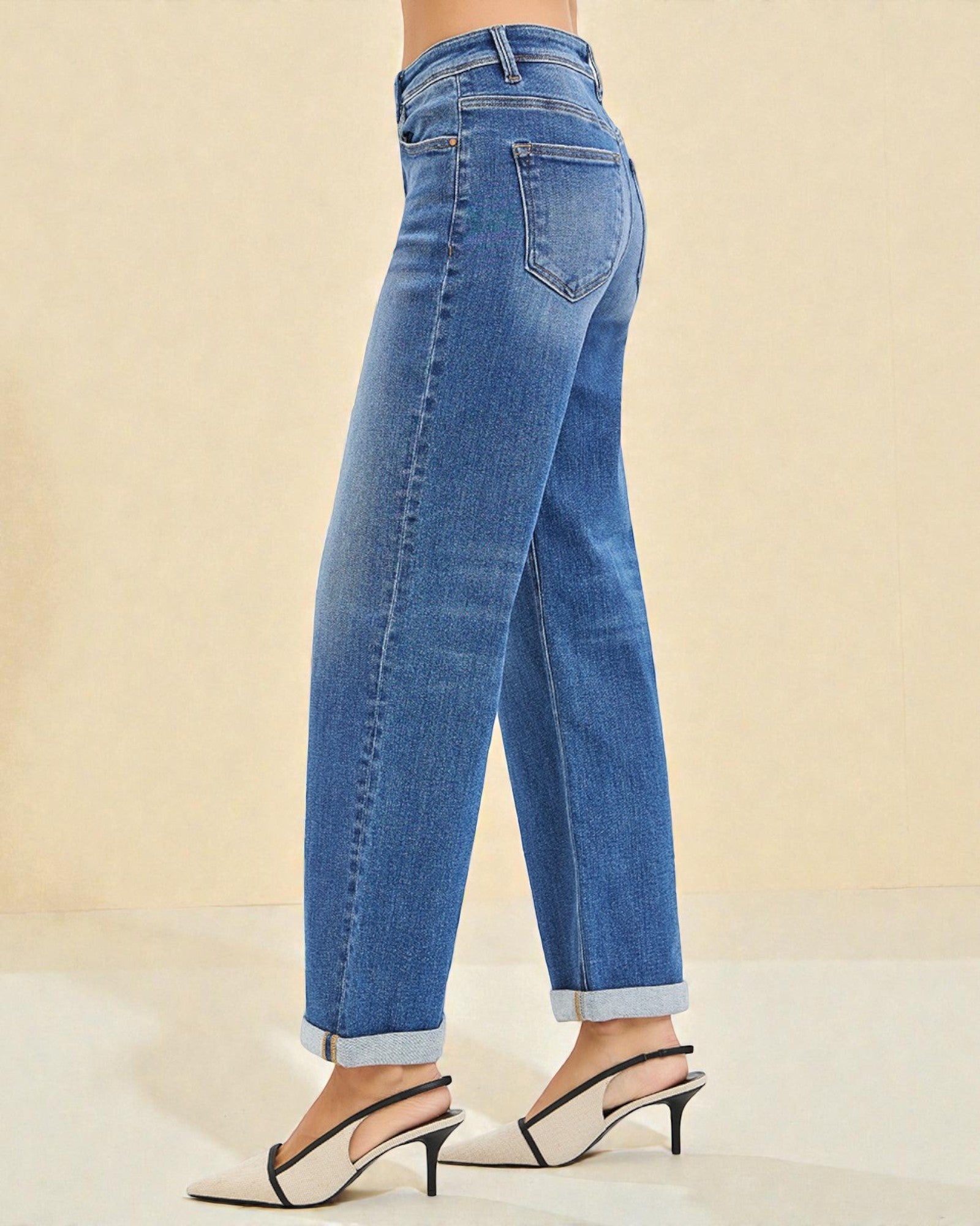 Blue jeans worn by a person on a beige background