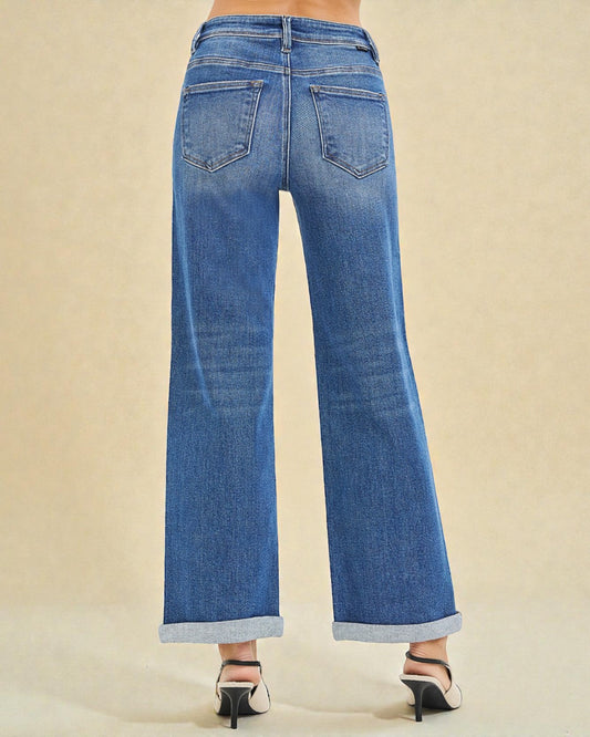 Blue jeans worn by a person on a beige background