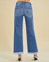 Blue jeans worn by a person on a beige background