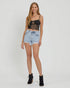 Woman wearing a black top and denim shorts on a white background