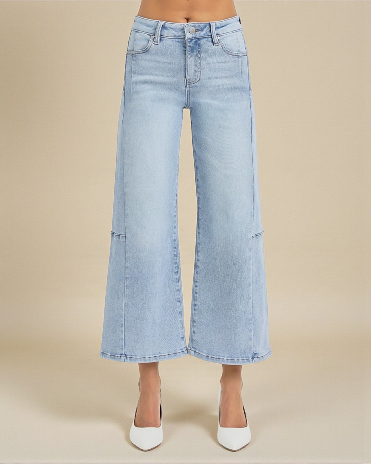 Light blue wide-leg jeans worn by a person on a beige background