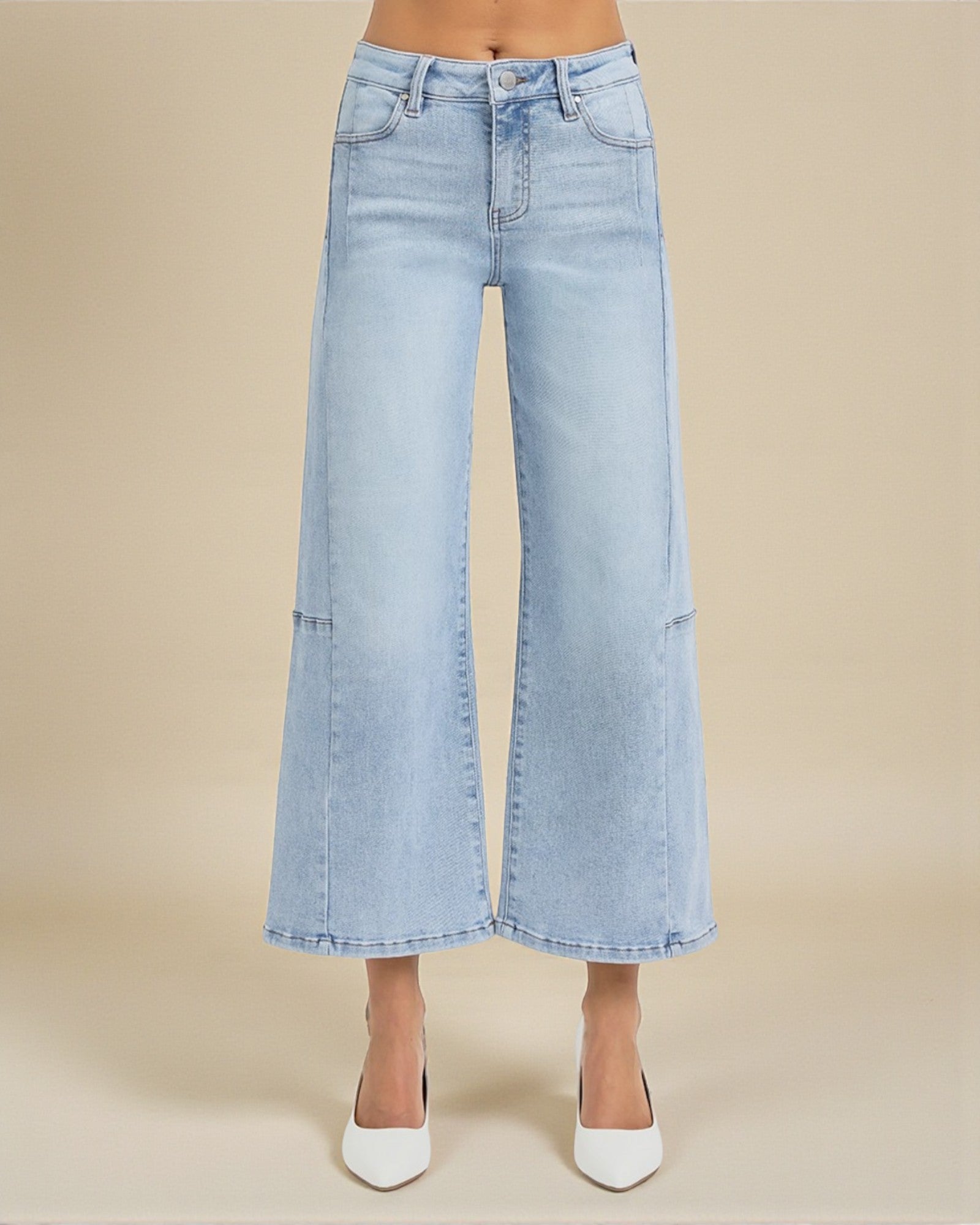Light blue wide-leg jeans worn by a person on a beige background