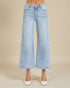 Light blue wide-leg jeans worn by a person on a beige background