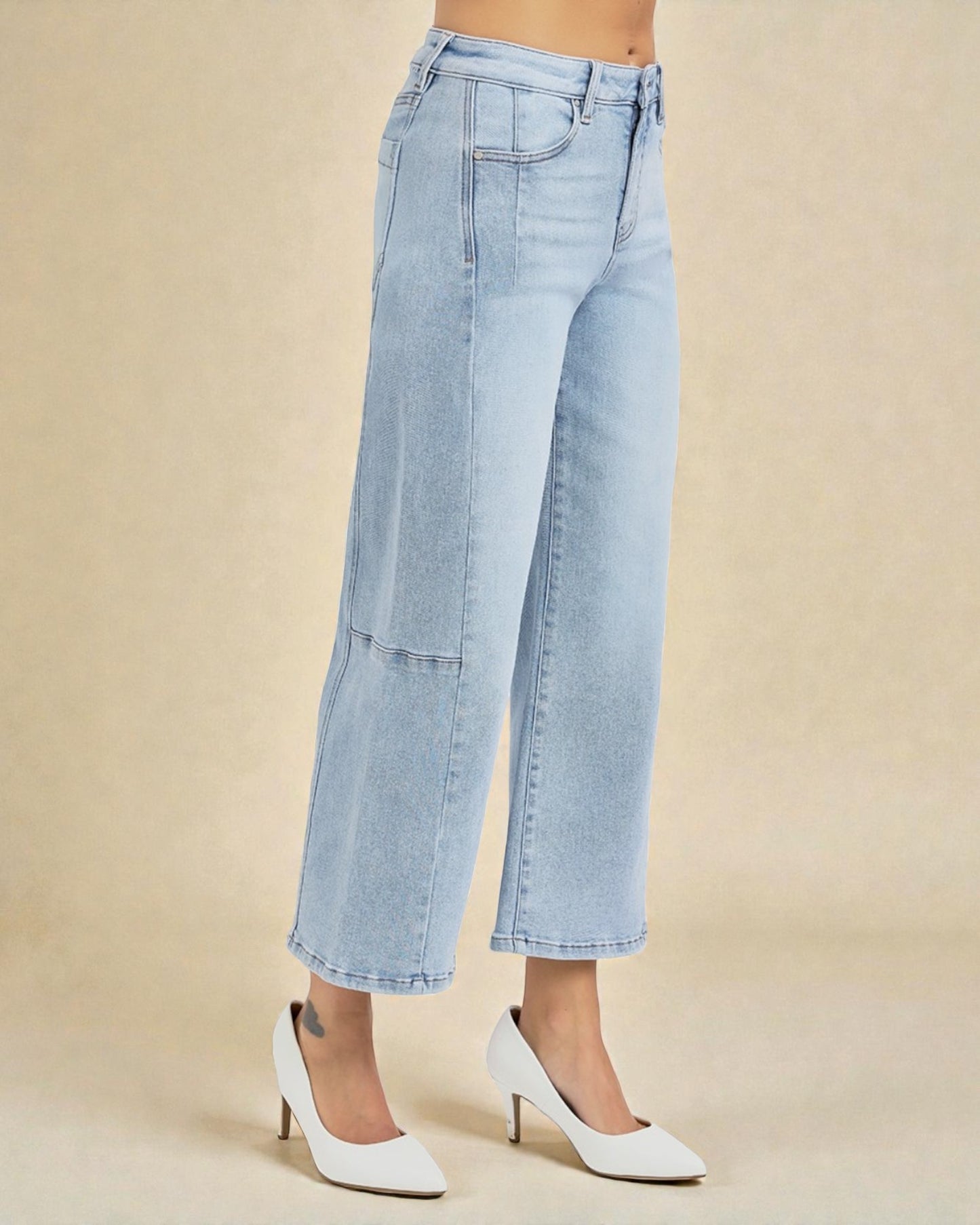 Light blue jeans worn by a person on a beige background