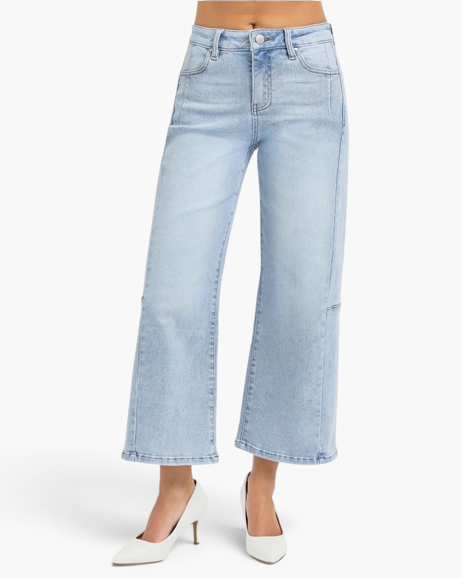Light wash blue cropped wide-leg jeans shown on a model from the waist down, paired with white pointed-toe heels against a clean white studio background.