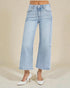 Light blue wide-leg jeans worn by a person on a beige background