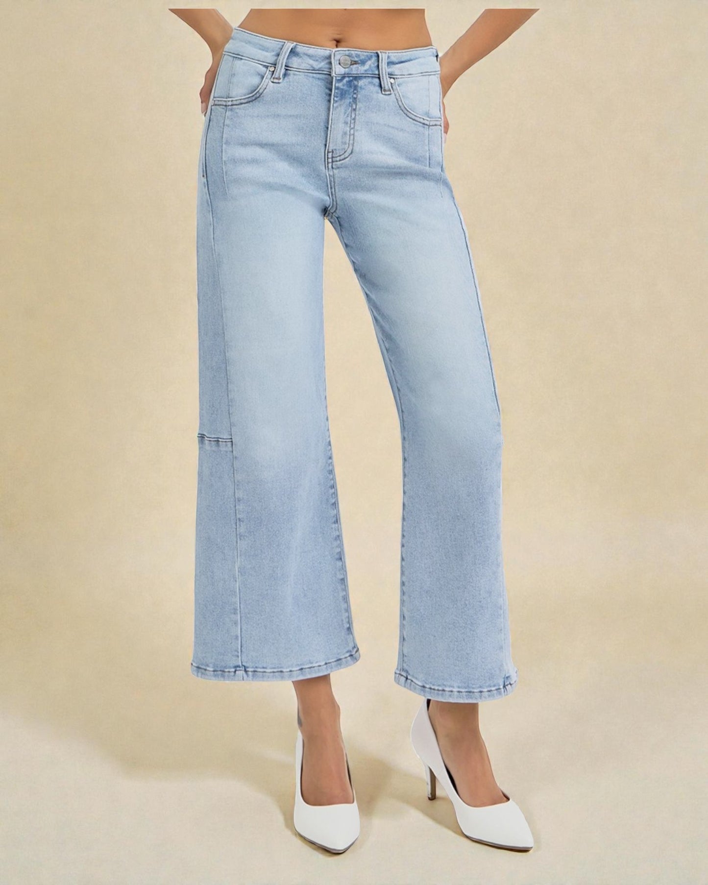 Light blue jeans worn by a person on a beige background